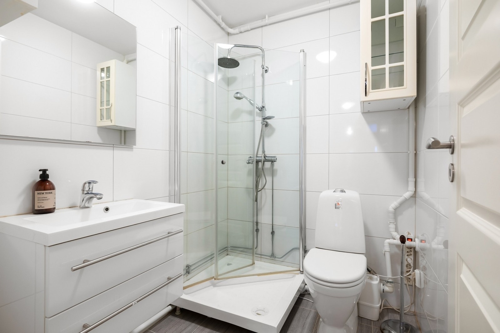 Bad separat del. Flislagte vegger og gulv med varmekabler. Servantinnredning med brede skuffer og helstøpt servantplate og speil. Dusjkabinett og gulvmontert toalett. Galleribilde