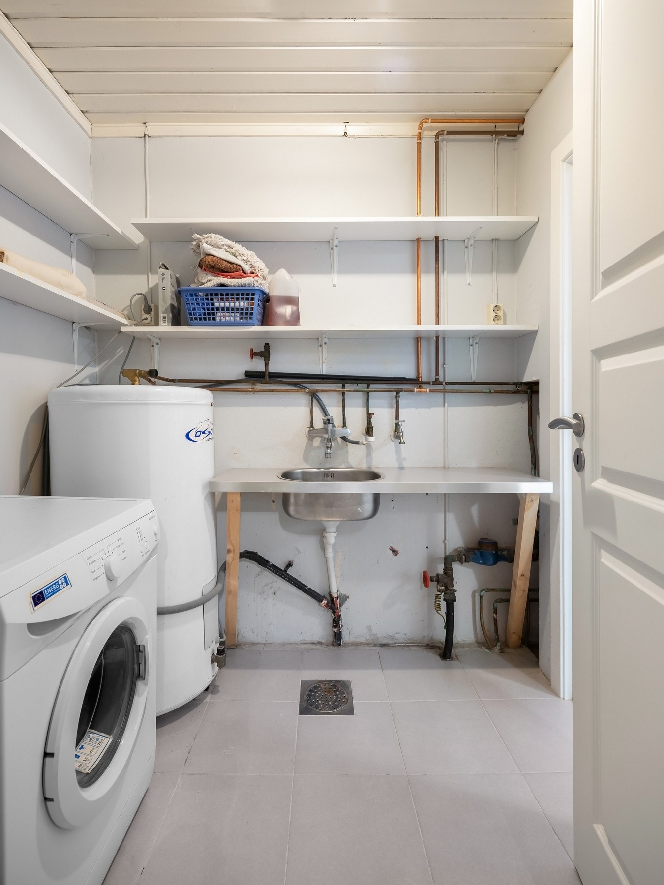 Vaskerom med flislagt gulv og malte veggflater, enkel innredning med skyllekar og opplegg for
vaskemaskin.
Rommet har innstallert varmvannsbereder og åpnet røranlegg i kobber med hovedstoppkran. Galleribilde