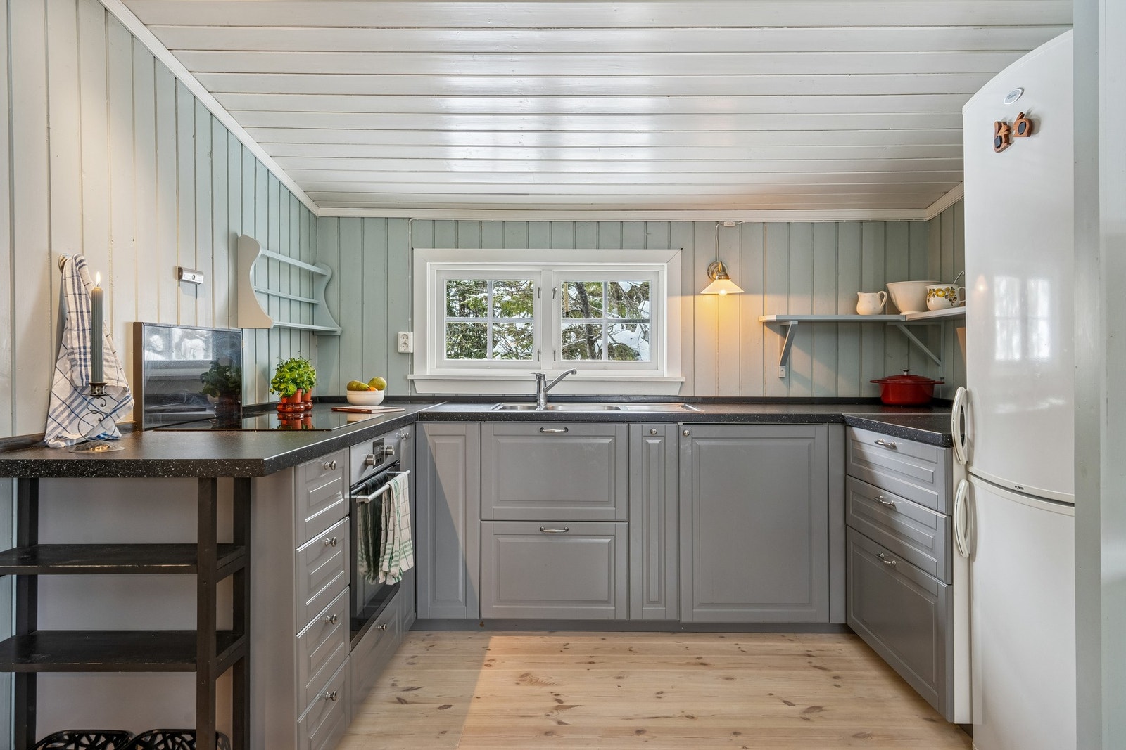 Nyere kjøkkeninnredning satt inn i perioden 2015/2016 av folierte plater malt i en fin gråfarge, med underskap, laminat benkeplate i trefylling og oppvaskkum med kran av stål. Galleribilde