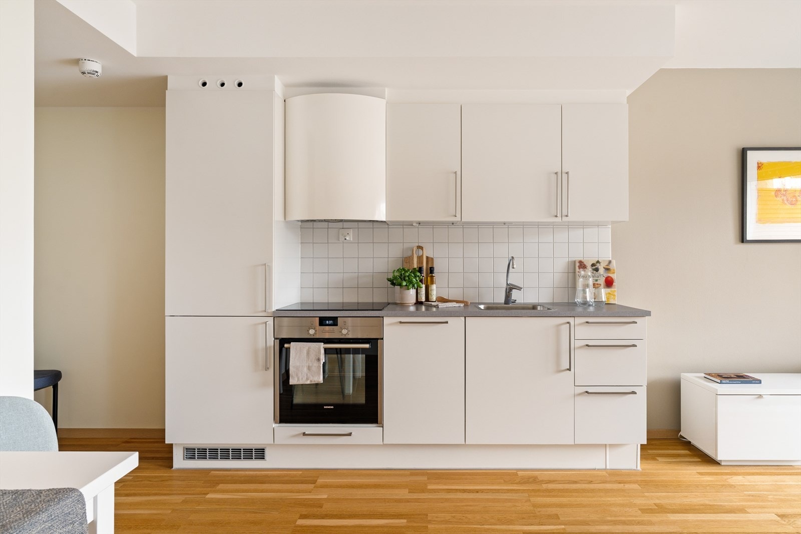 Flott kjøkken i praktisk utforming langs vegg, med god skap- og benkeplass. Kjøkkenet er vurdert til tilstandsgrad 1 av takstmann Galleribilde