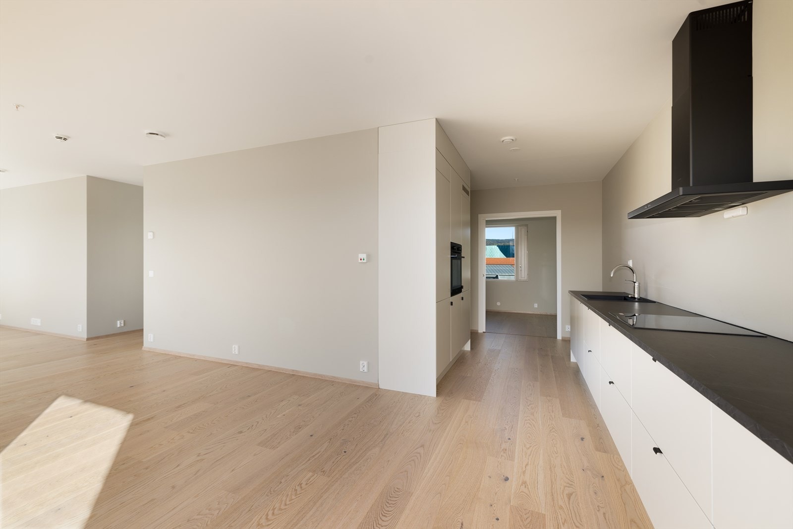 Delikat kjøkkendel i åpen løsning, med kvalitetskjøkken fra den norske kjøkkenprodusenten Sigdal. Integrerte hvitevarer. Galleribilde