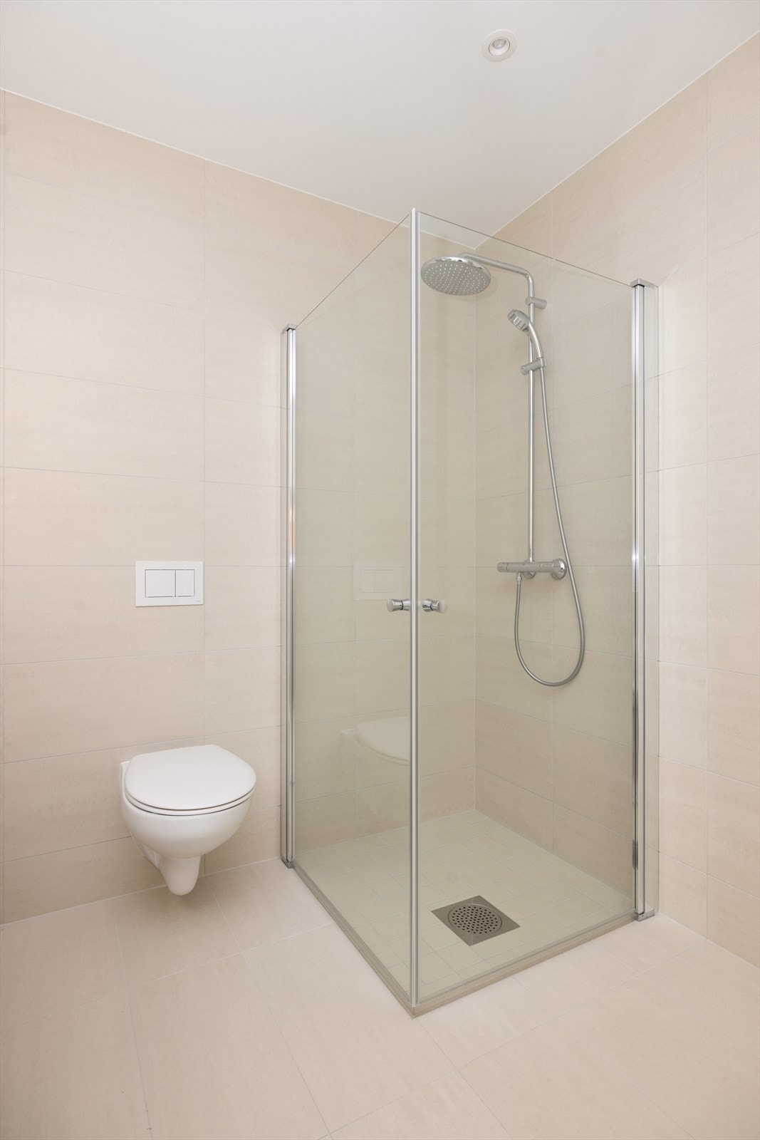 Badet har for øvrig veggmontert toalett og nedsenket dusjområde med innfellbare dusjvegger, samt opplegg for vaskemaskin. Galleribilde