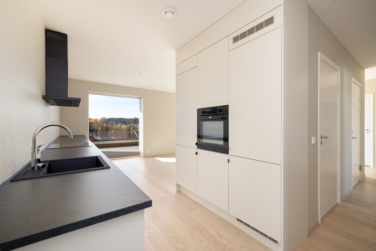 Laminat benkeplate med gode arbeidsflater, nedfelt komposittvask og nedfelt induksjonstopp. Det er montert komfyrvakt. Galleribilde