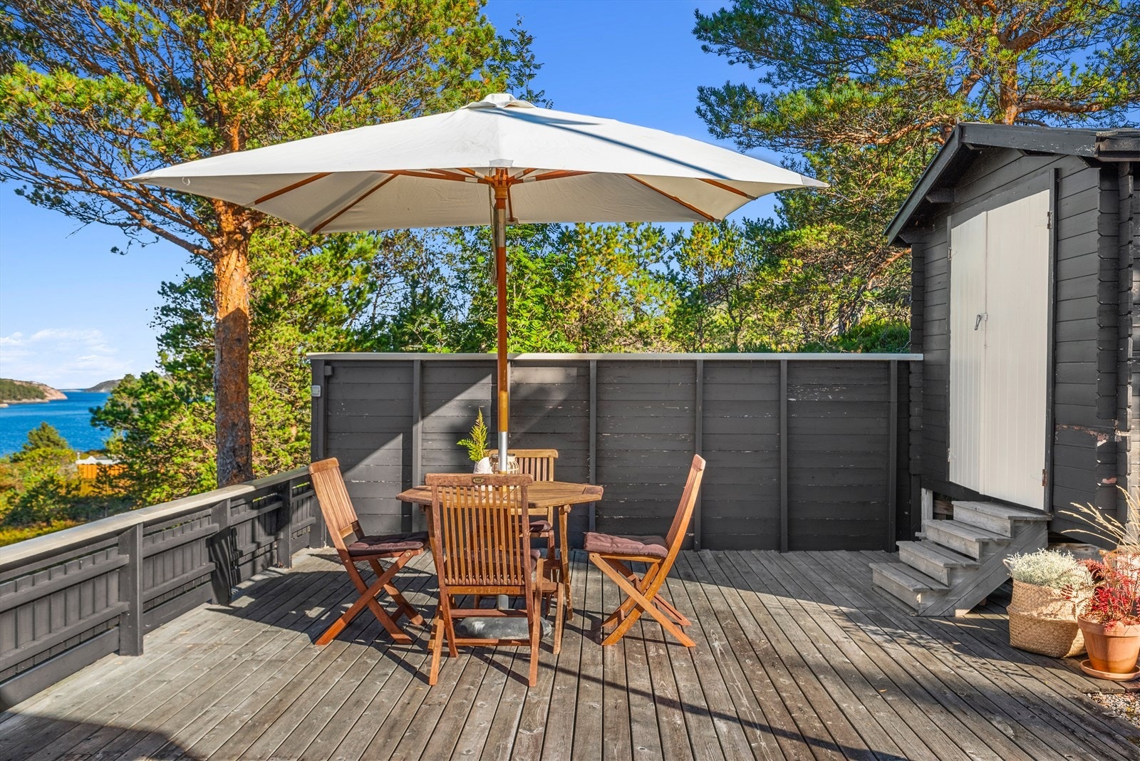 Fritidsboligen byr på en lun uteplass, godt beskyttet mot vær og vind gjennom både levegg og frodig vegetasjon. Galleribilde