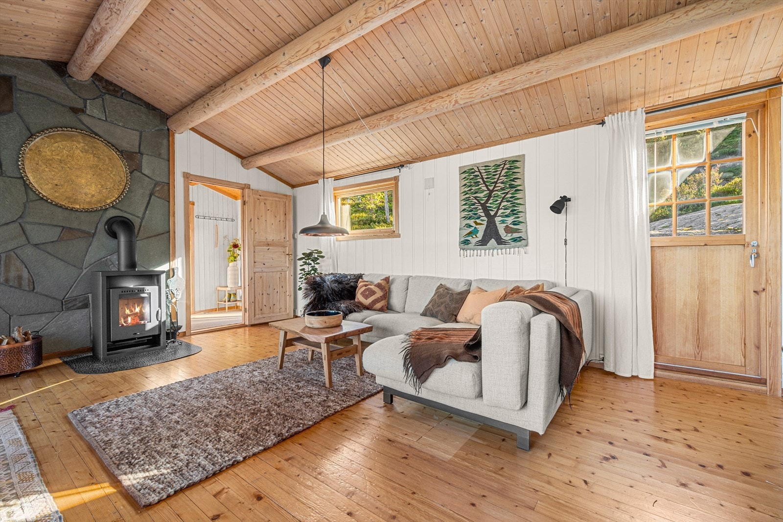 Fritidsboligen har et luftig og innbydende allrom på hele 27 m², hvor de store vindusflatene gir en spektakulær utsikt mot omgivelsene. Galleribilde