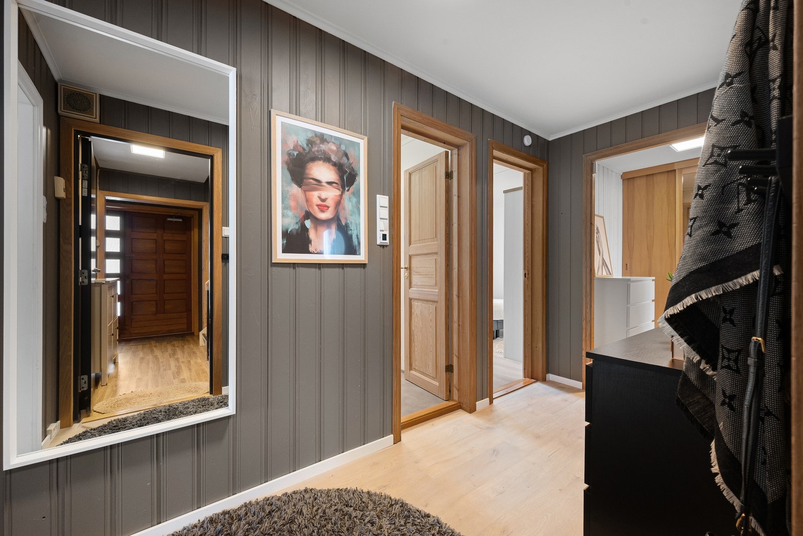 Romslig gang som skaper et naturlig skille mellom rommene, med sosiale og private rom i hver sin ende Galleribilde