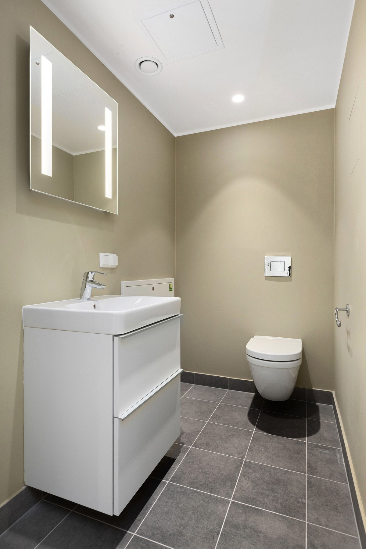 Leiligheten har også et praktisk separat wc med duse fargetoner, vegghengt toalett og servant - et etterspurt og funksjonelt tillegg i hverdagen. Galleribilde