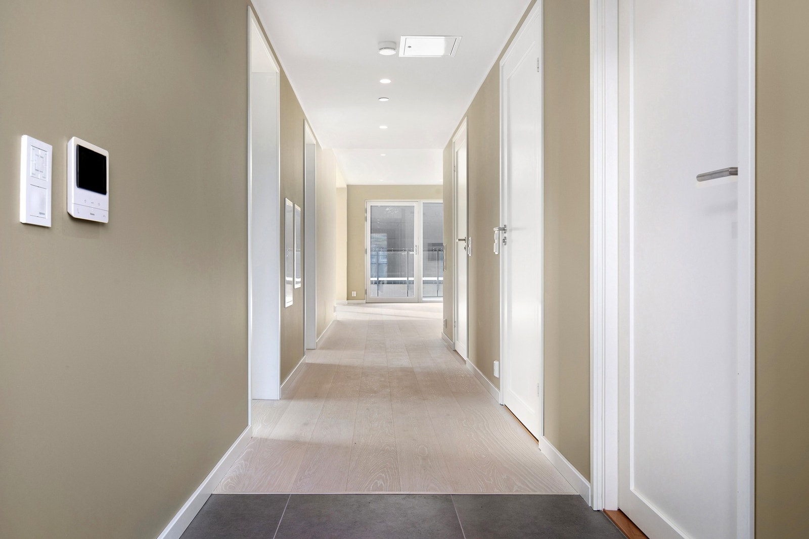 Leiligheten har en romslig og innbydende entré med flislagt gulv og varmekabler - praktisk og komfortabelt i hverdagen. Videre innover er det god plass til garderobeløsning og oppbevaring, og et ryddig førsteinntrykk av boligen. Galleribilde