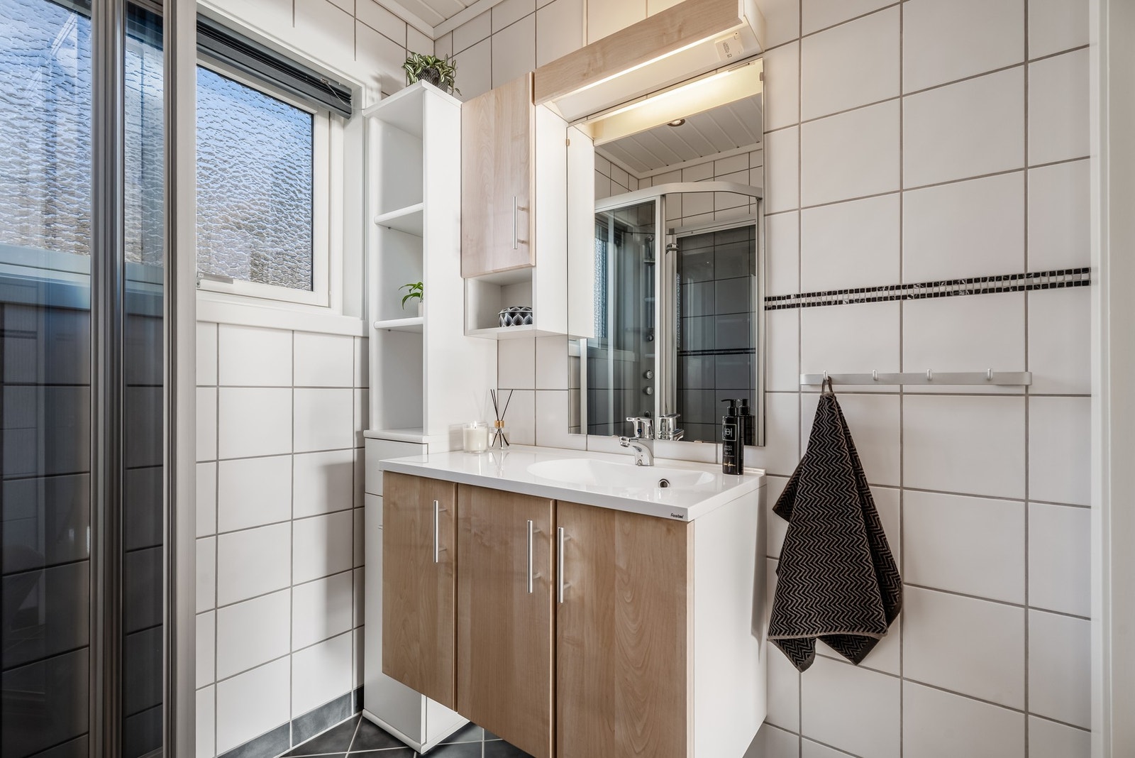 Pent og tidløst bad som har gode oppbevaringsmuligheter i servantinnredning og skap. Galleribilde