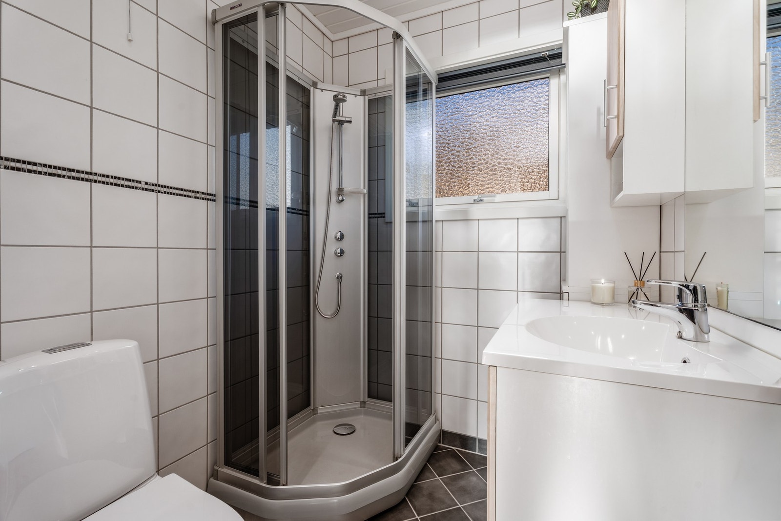 Badet som har standard fra 2003 har flislagte overflater og varme i gulv. Toalett og servantinnredning fra 2022. Galleribilde