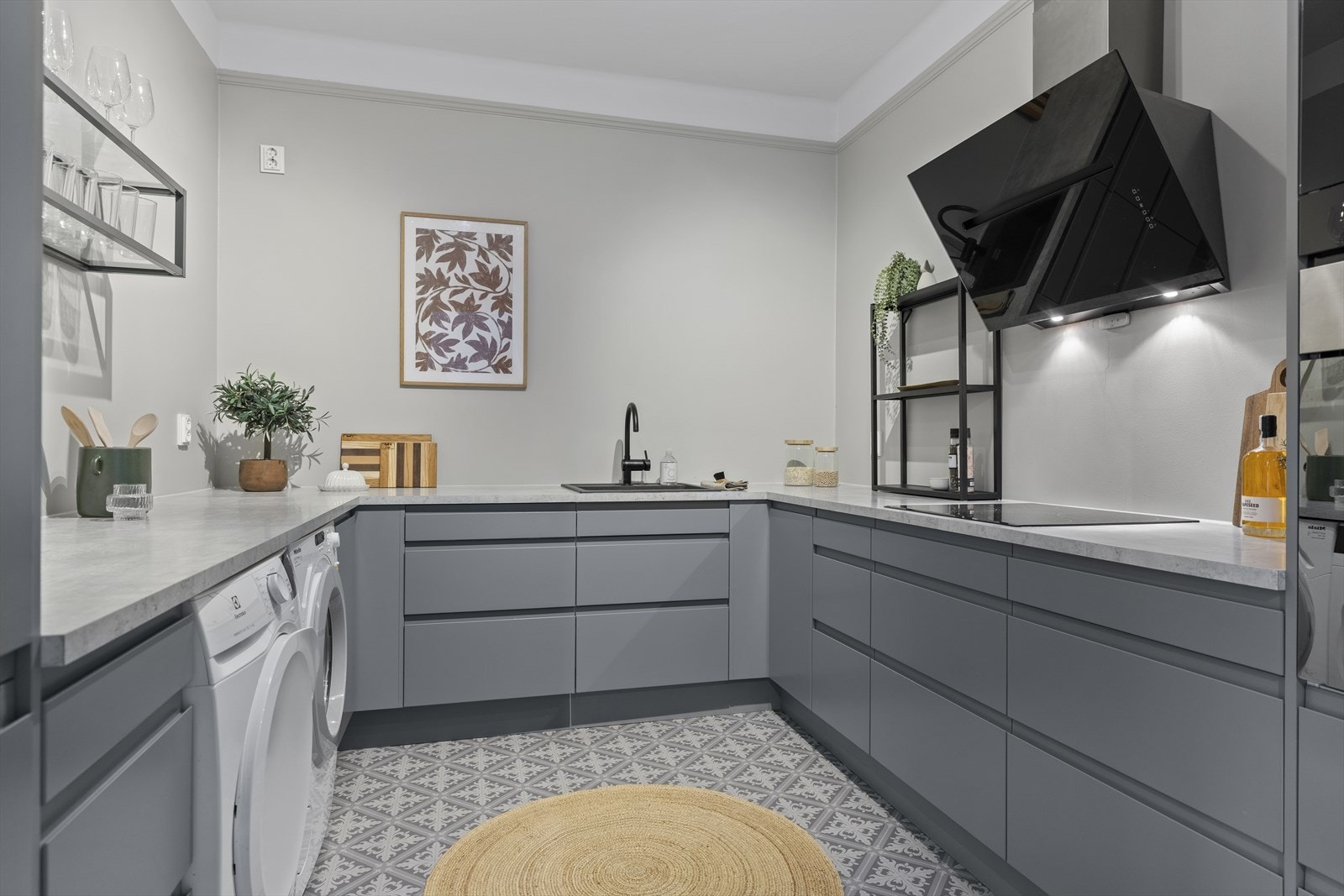 Innredningen har glatte fronter og laminat benkeplate med nedfelt kum i kompositt og tilhørende blandebatteri. Galleribilde