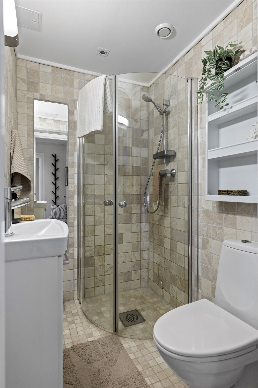 Badet har marmorfliser på veggene, med innfelt speil i bakveggen, og mosaikkfliser i marmor på gulvet. Galleribilde