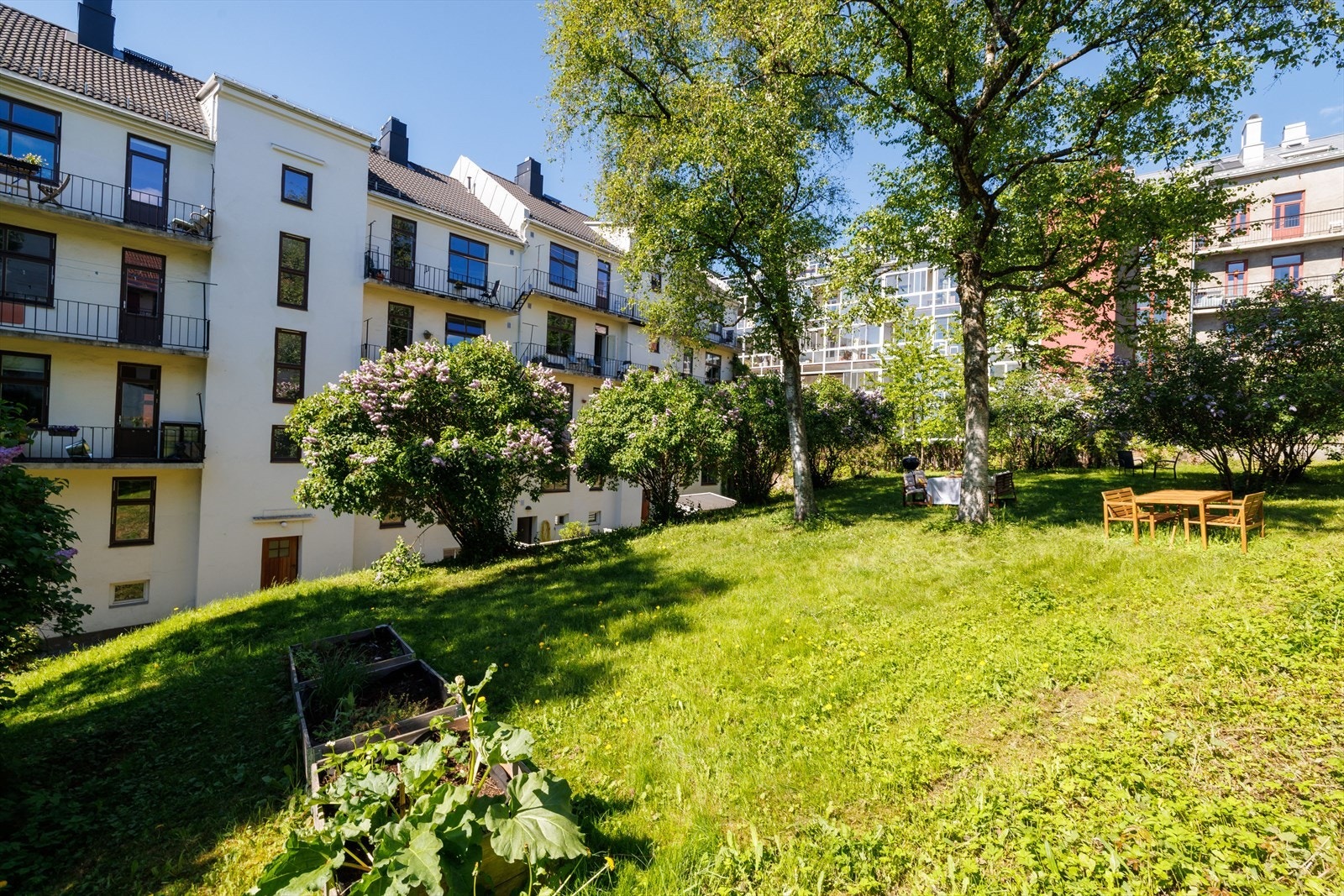 Bakgården fremstår som en stille og skjermet oase midt i byen, med gode solforhold og hyggelige oppholdsplasser Galleribilde