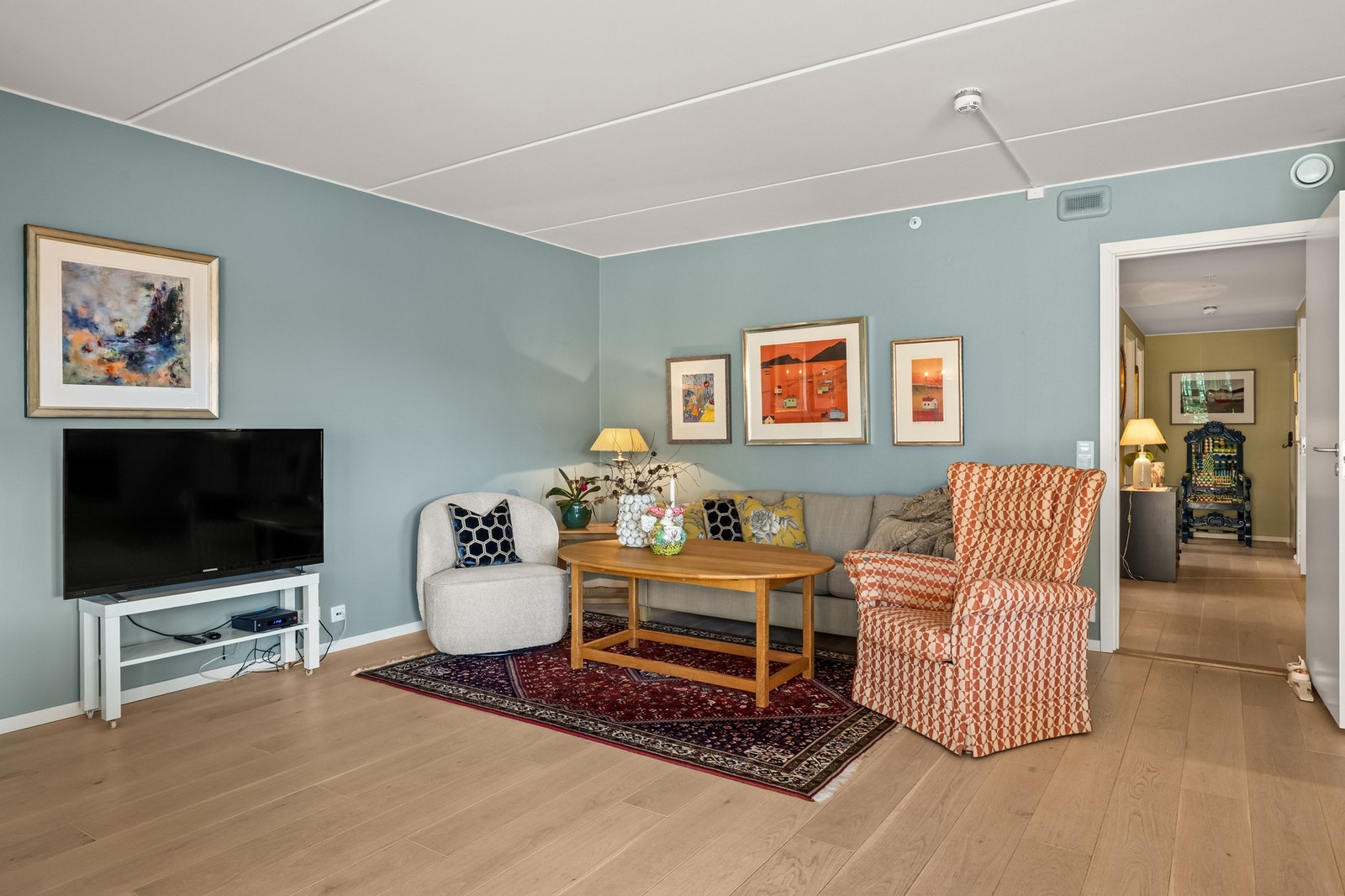 Stuen er malt i en dus fargetone og oppleves som et innbydende oppholdsrom. Galleribilde