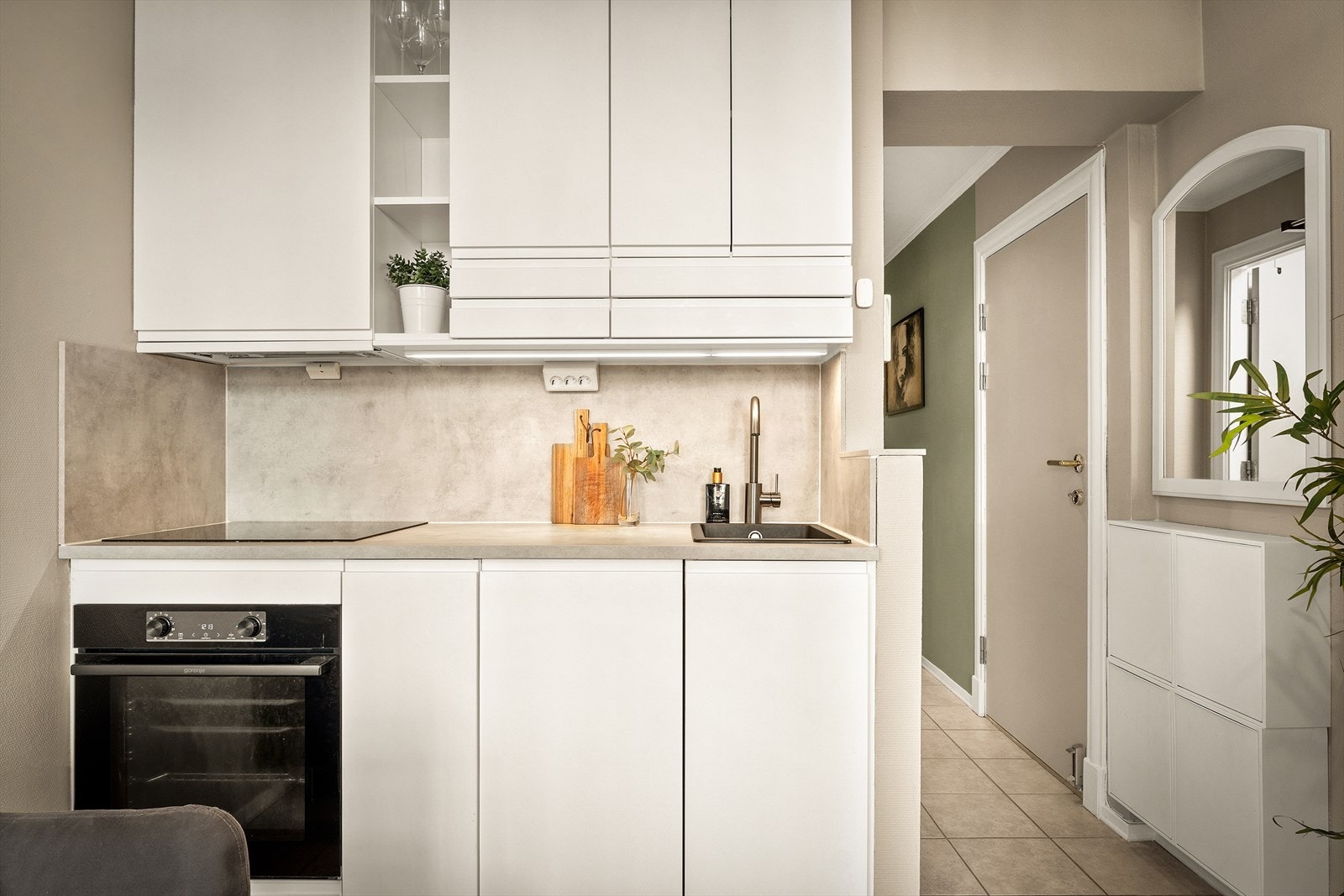 Til tross for kjøkkenets mindre størrelse er det gjennomgående gode oppbevaringsløsninger som legger til rette for orden og effektiv utnyttelse av plassen. Galleribilde