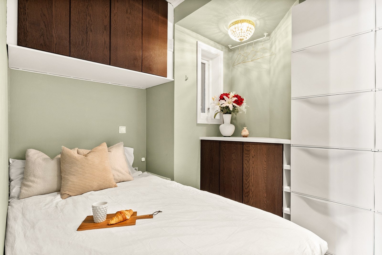 Rommet er malt i en behagelig grønnfarge og har skap i moderne valnøttnyanse, som gir både varme og kontrast. Galleribilde