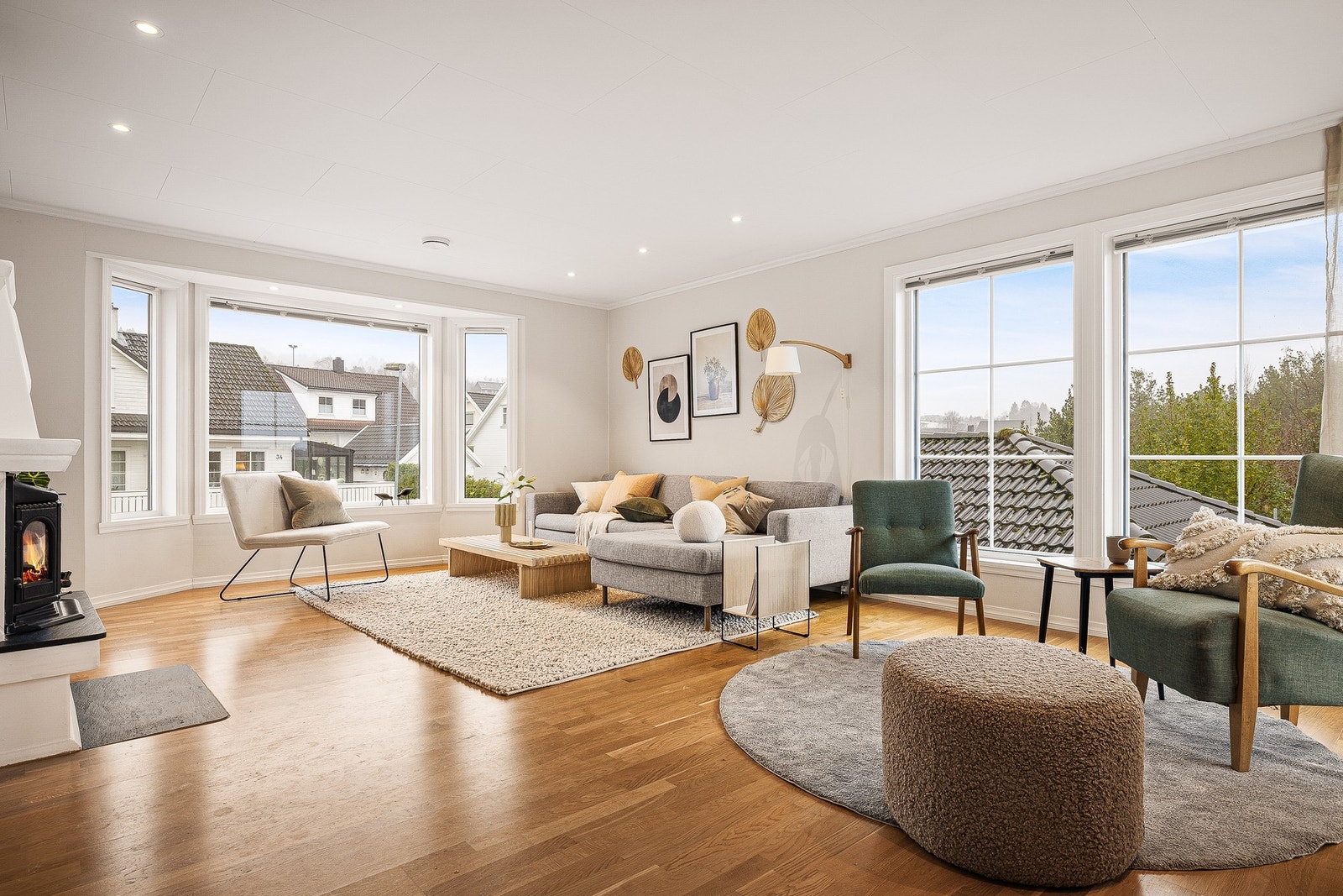 Velkommen inn i en romslig stue med lyse og tidsriktige overflater Galleribilde