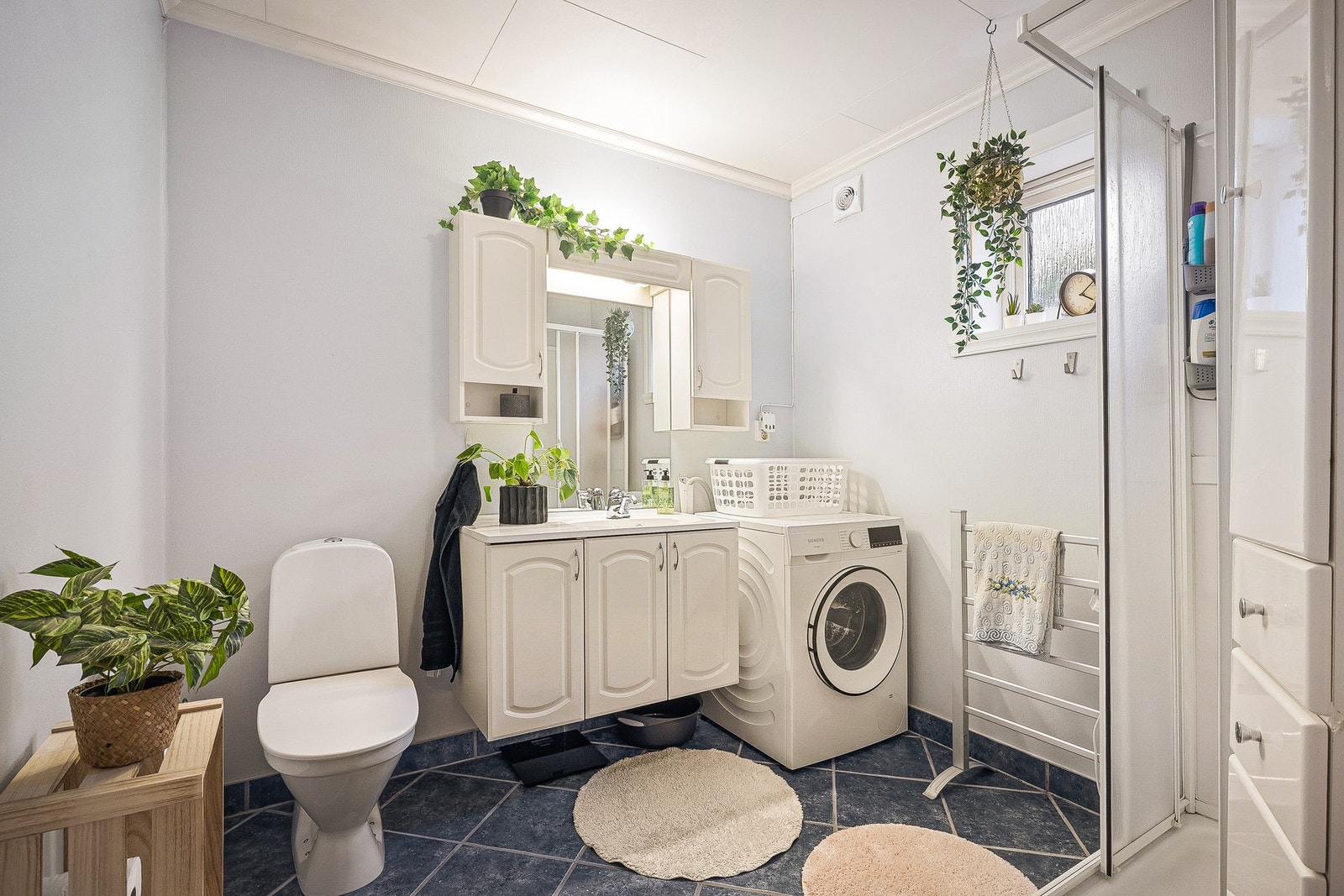 Badet i utleiedelen er 5,7 kvm og har keramiske fliser på gulv, malte strievegger og takplater i taket. Badet er innredet med servant med tilhørende baderomsmøblement, speil og belysning, samt toalett og dusjkabinett. Her er det opplegg for vaskemaskin Galleribilde