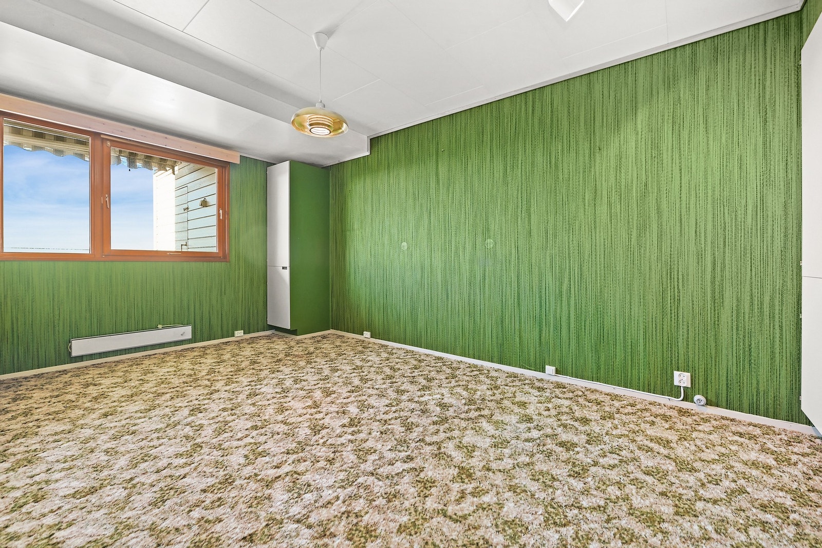 Soverommet har et tydelig retro-preg med grønn tapet og vegg-til-vegg-teppe. Galleribilde