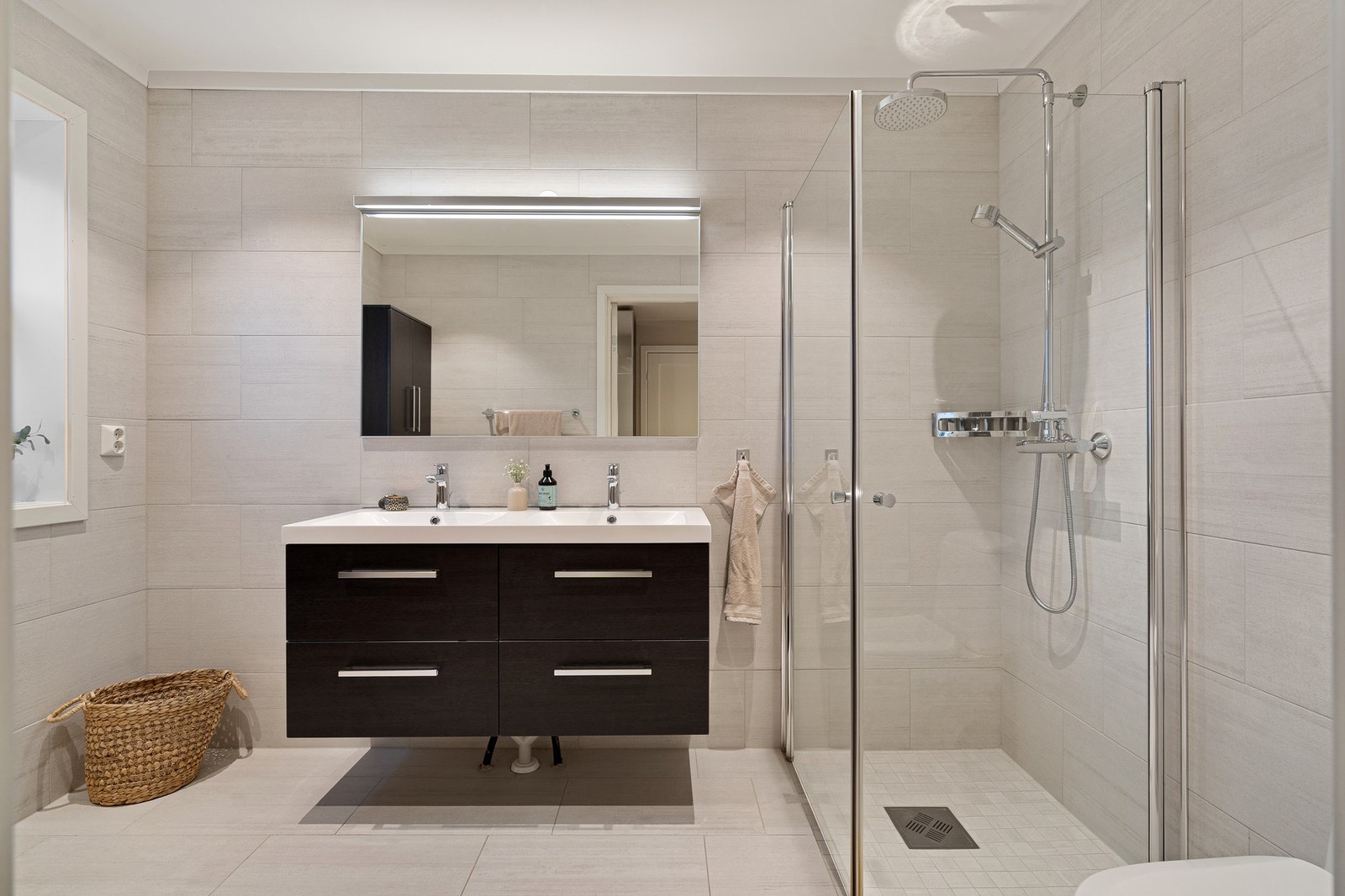 Boligen inneholder to flislagte bad - ett i første etasje og ett i tredje - begge utført med lekre, moderne fliser og innredet med dusjhjørne, toalett og servant. Galleribilde