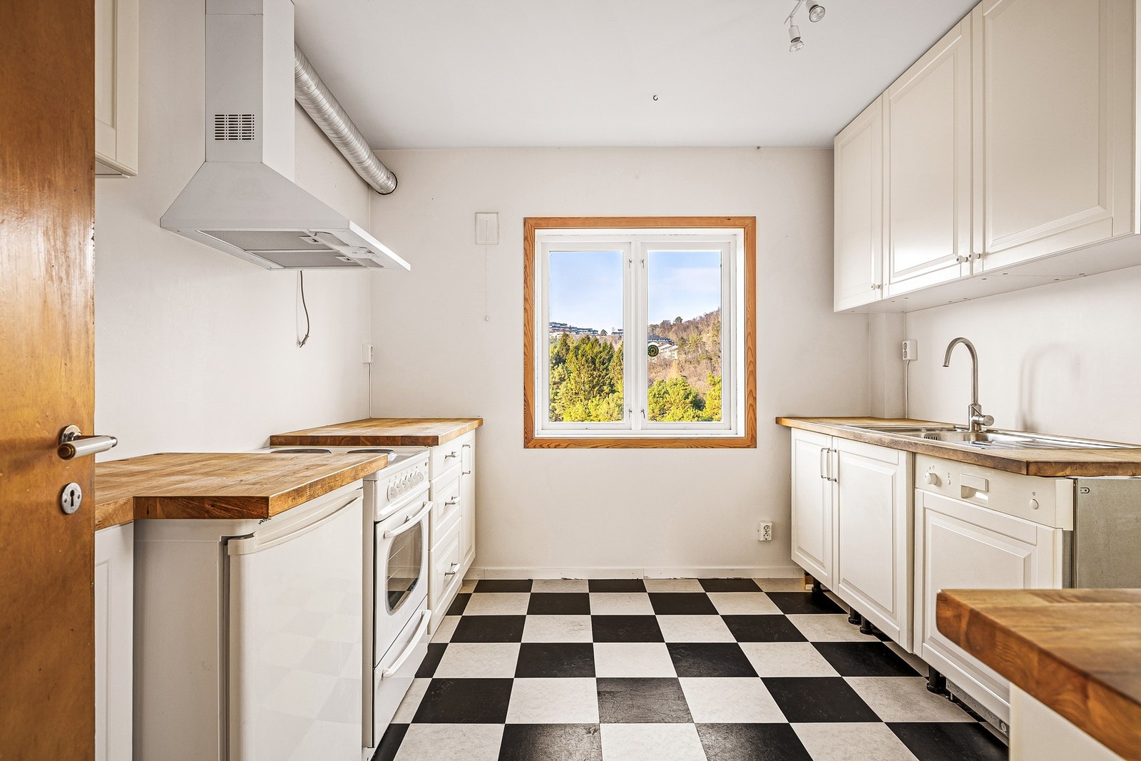 Kjøkkenet har belegg på gulv og kjøkkeninnredning med profilerte fronter og heltre
benkeplate med nedfelt vask av stål og ventilator. Galleribilde