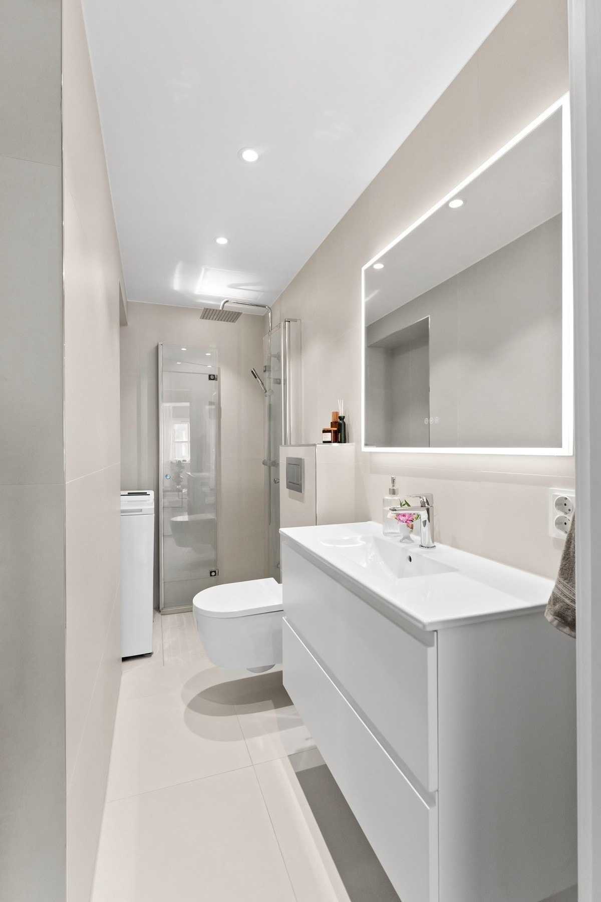 Delikat flislagt baderom i lys utførelse, totalrenovert i 2024. Badet er utstyrt med nedsenket dusjhjørne med svingdører i glass og regnfallsdusj Galleribilde