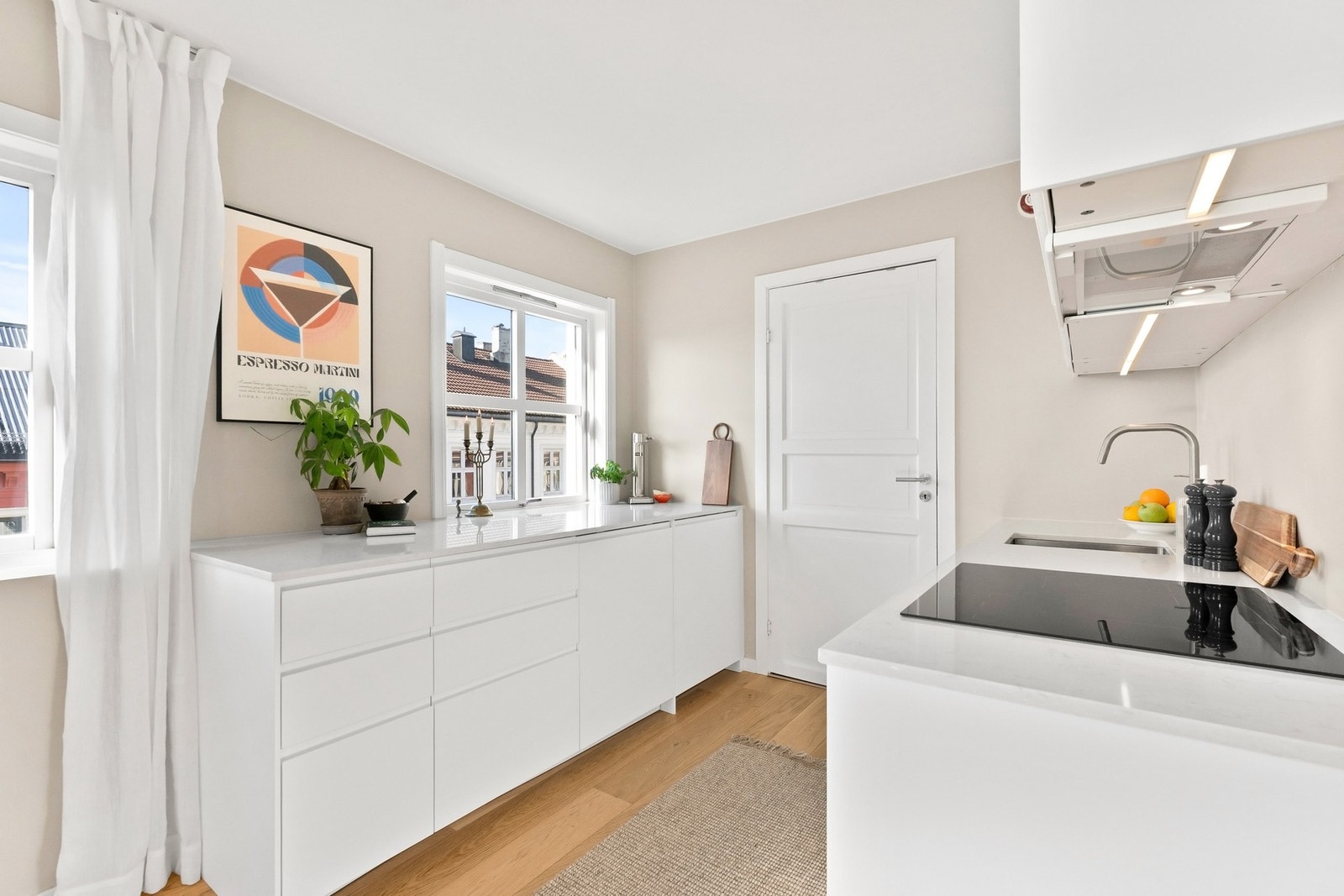 Flott kvalitetskjøkken fra 2024, utført med glatte fronter og slitesterk benkeplate i stein Galleribilde