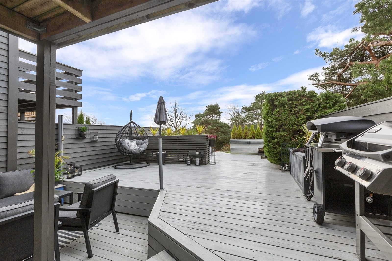 Uteplassen er skjermet med levegger og hekk. Nedenfor ligger friområde og uteplassen oppleves som et privat og fredelig sted å være. Galleribilde