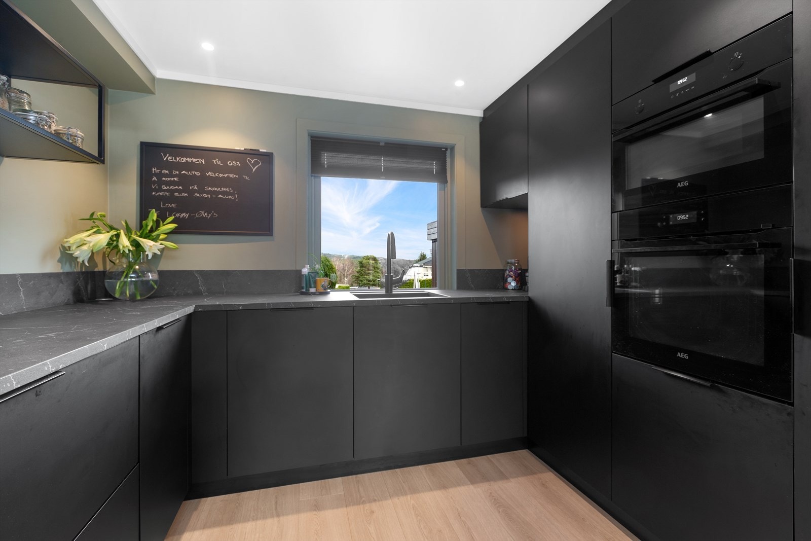 Kjøkkenet er fra 2023 og har mørk slett innredning og laminat benkeplate med planlimt kum i komposittmateriale for et stilrent uttrykk. Galleribilde