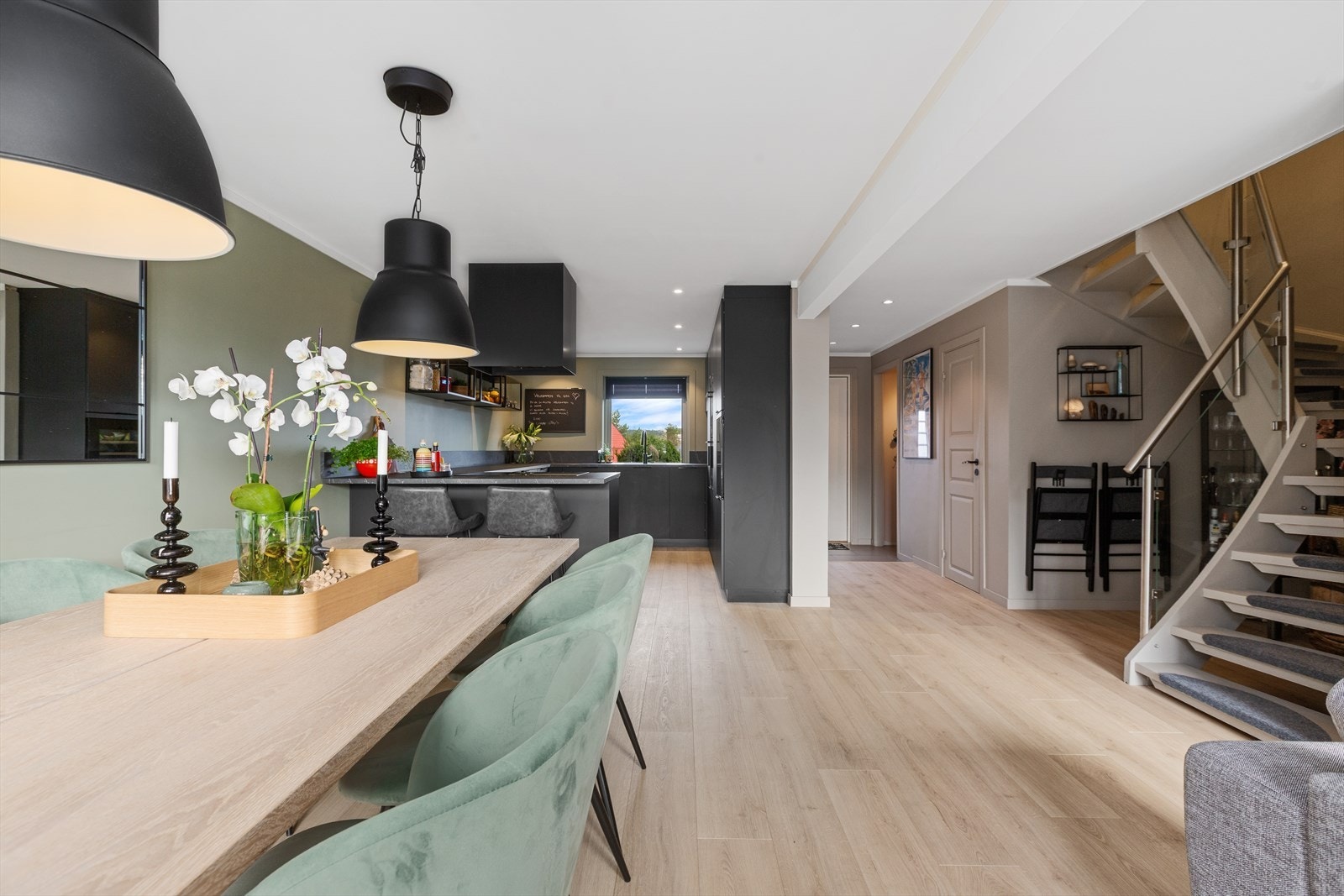 Den åpne løsningen mot kjøkkenet gir en sosial og moderne atmosfære - perfekt for både hverdagsliv og gjester. Galleribilde