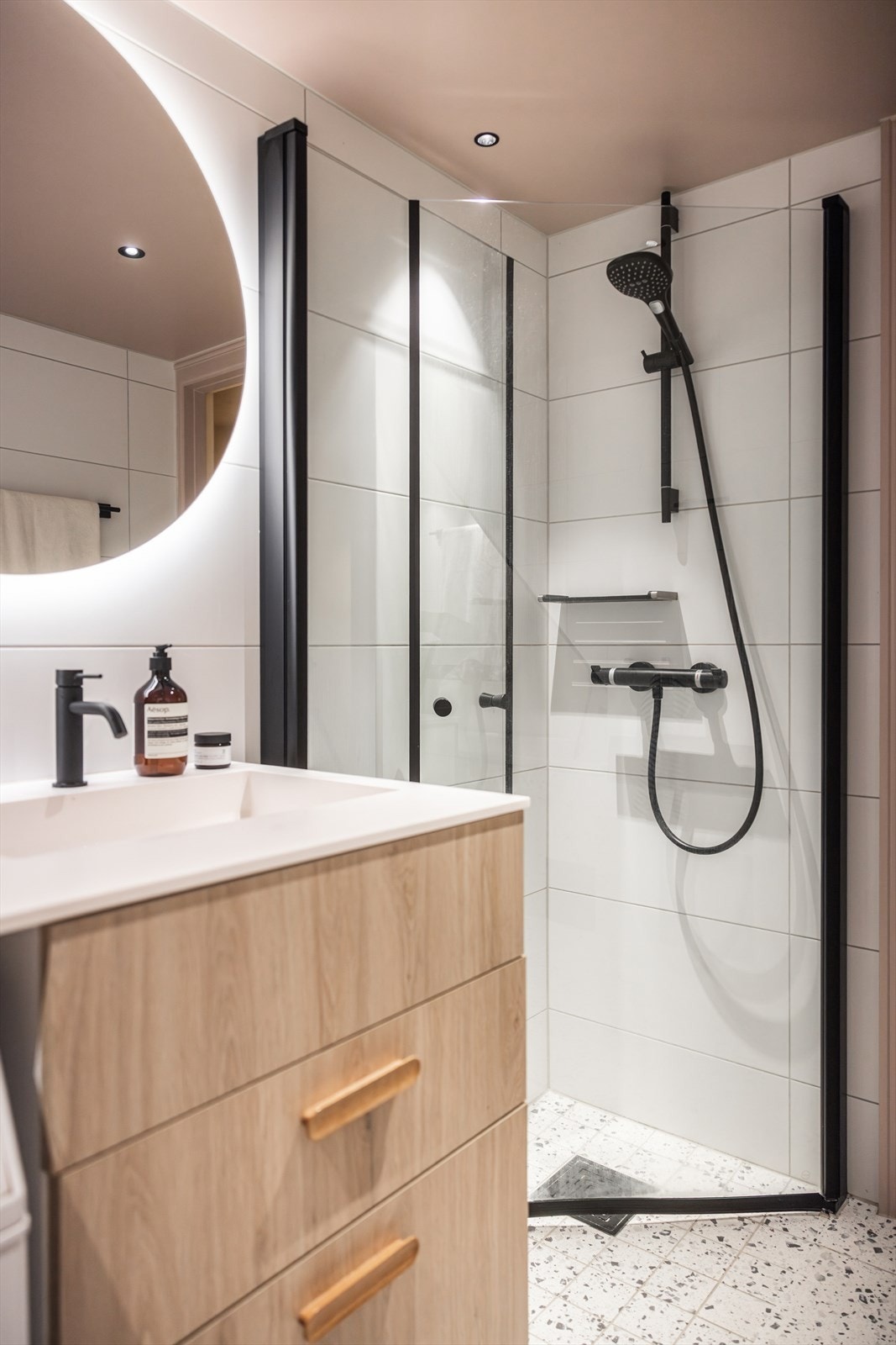 Badet er utstyrt med vegghengt wc, servant med skuffer under med heldekkende Corian benkeplate og dusj i hjørne med innadslående dører. Videre er det innmurt badekar, samt opplegg for vaskemaskin og tørketrommel. Galleribilde