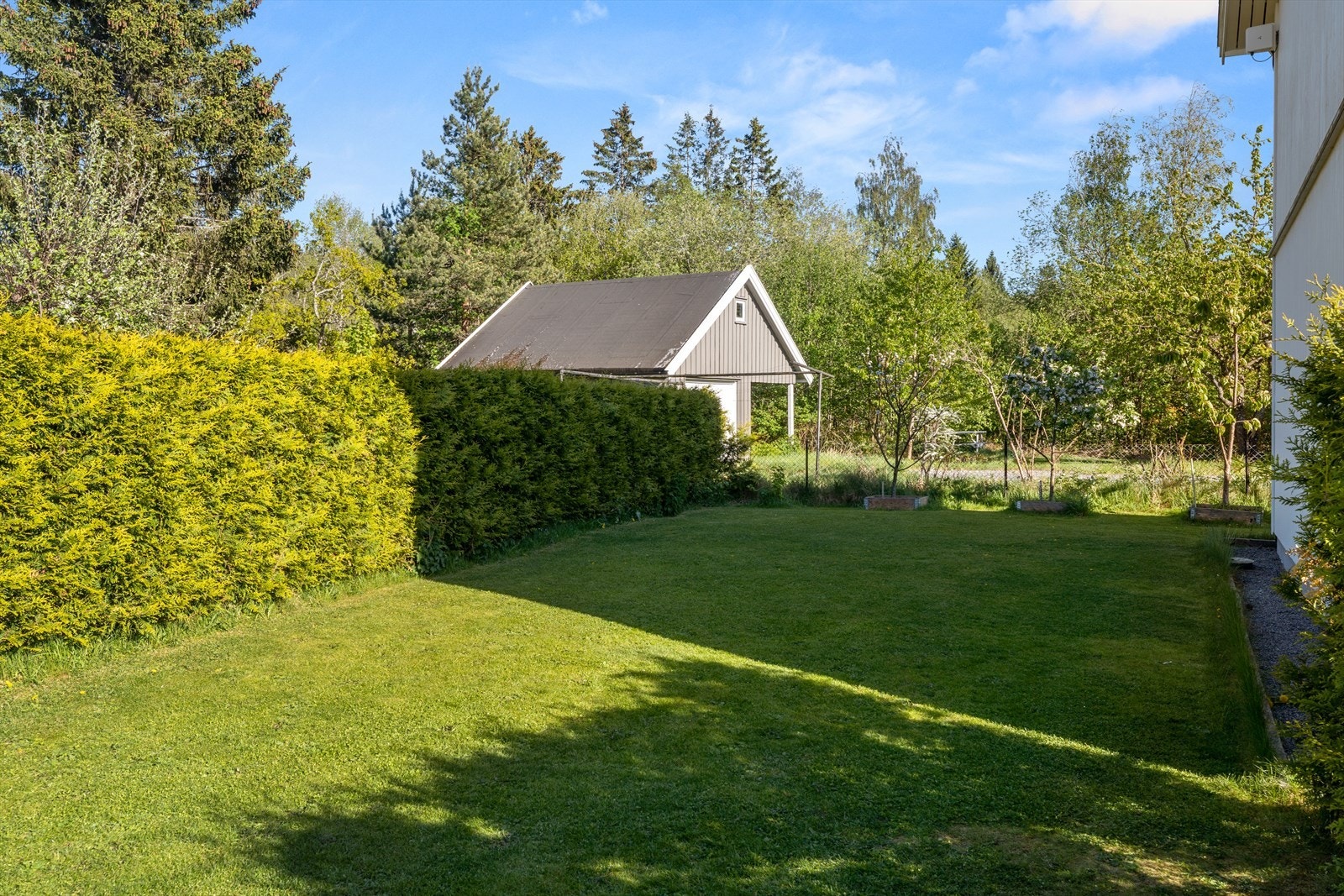 Utsikt mot hagen og lysthuset fra baksiden av boligen. Galleribilde