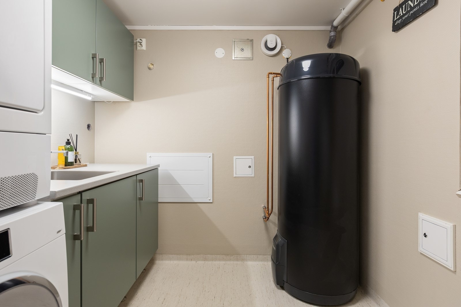 Praktisk vaskerom med smart vaskeromsinnredning. Det er opplegg for både vaskemaskin og tørketrommel. Galleribilde