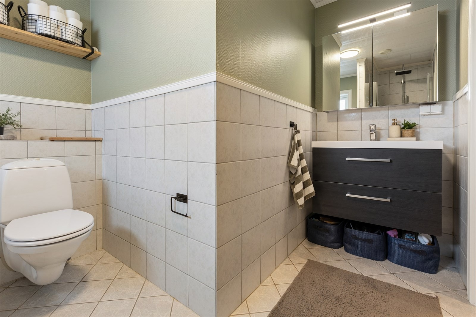 Badet er for øvrig utstyrt med vegghengt toalett og en stilren og moderne baderomsinnredning. Badet har behagelige varmekabler i gulv. Galleribilde