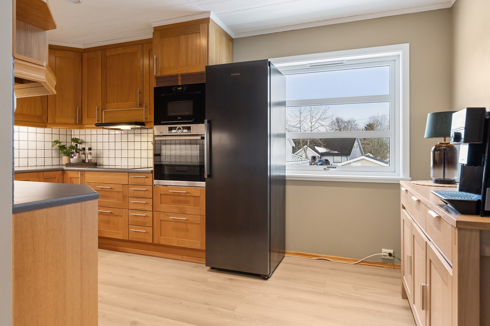 Kjøkkenet er lyst og pent. Innredning med profilerte fronter i eik, og benkeplate av typen laminat. Galleribilde