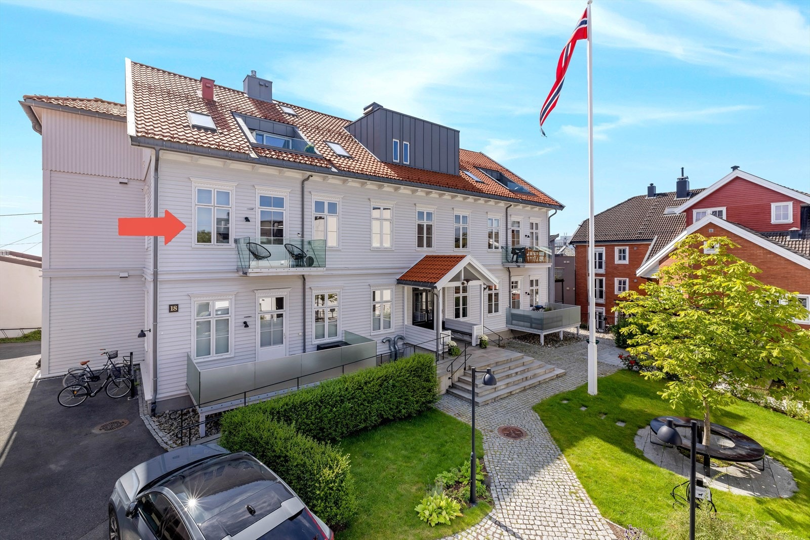 Leilighet markert med pil. Sameiet ligger i et klassisk pent skolebygg opprinnelig oppført ca. 1870 og leilighetene i bygget ble laget ca. 2019. Svært pent opparbeidede områder like utenfor døren. Galleribilde