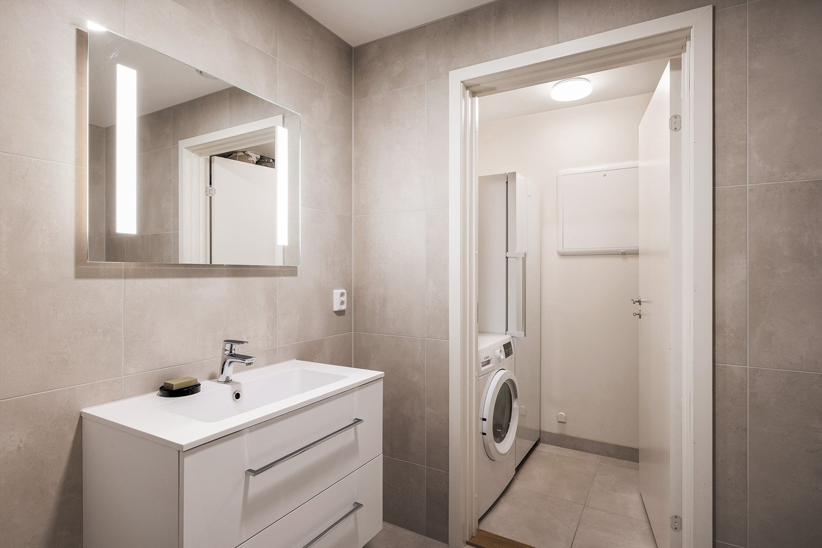 Badet i 1. etasje er på 4m² med keramiske fliser på gulv/vegger og malt platekledning i himling Galleribilde