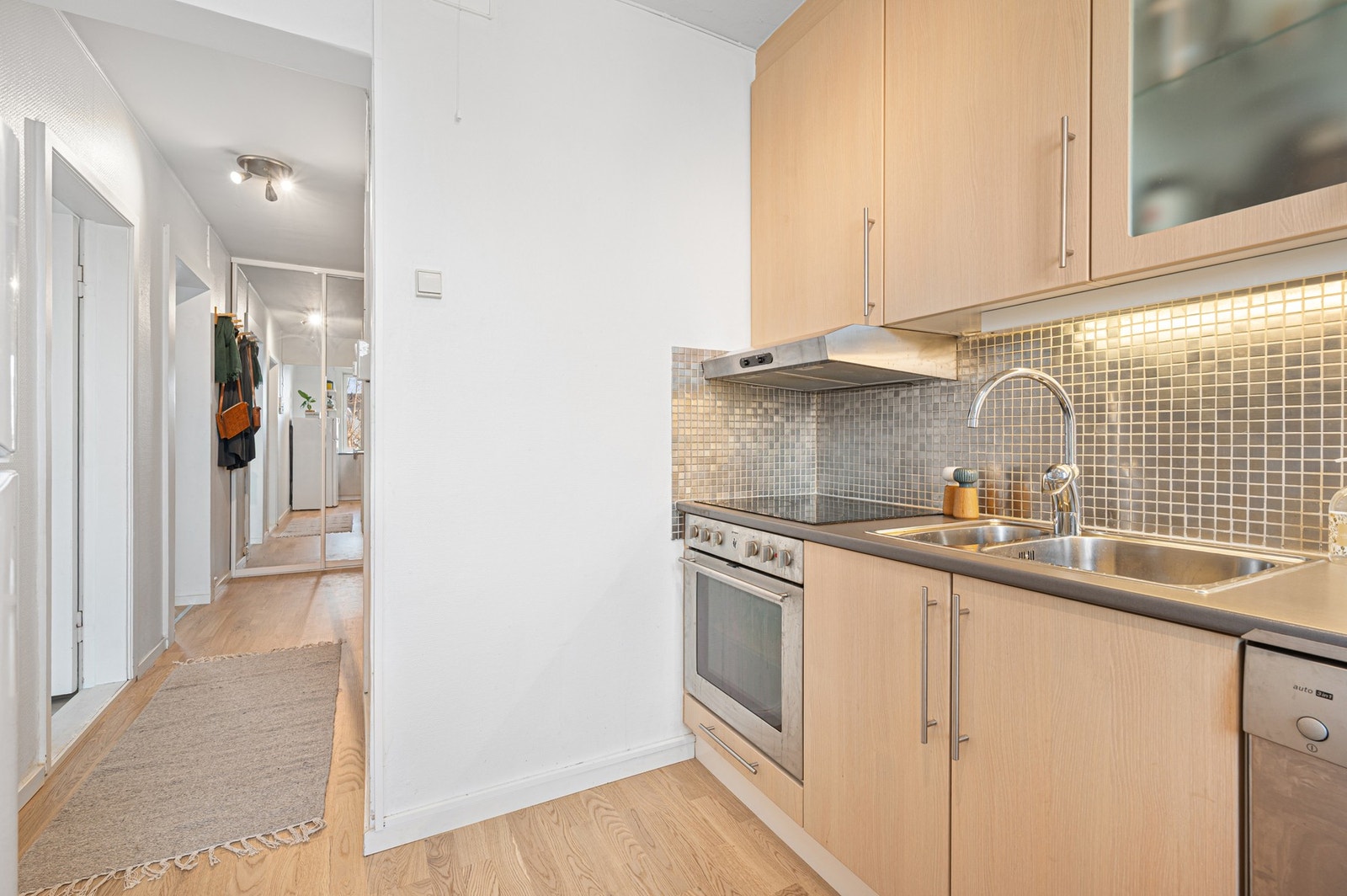 Fra kjøkkenet er det en praktisk overgang til entré og resten av boligen, noe som gir en funksjonell planløsning. Galleribilde