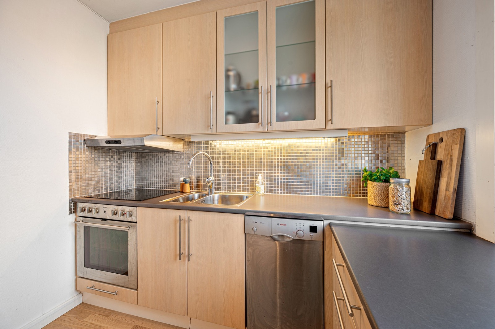 Kjøkkenet har innredning med glatte fronter. Benkeplaten er av laminat. Galleribilde