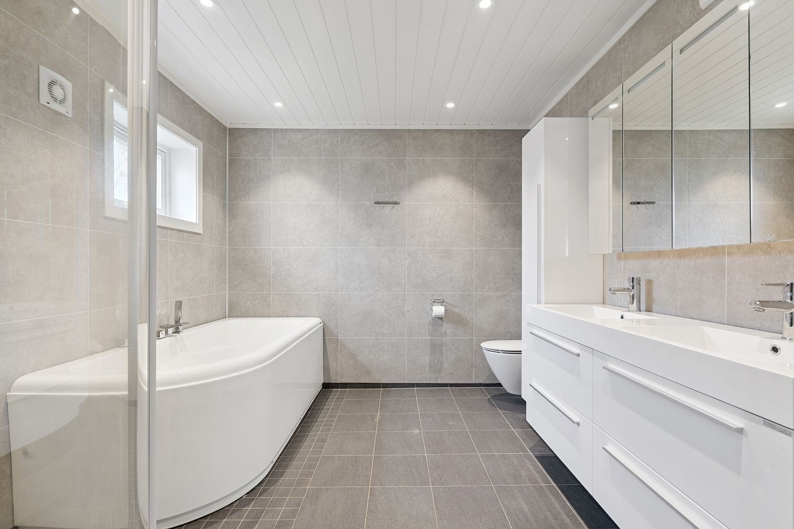 Smakfullt baderom utført i en harmonisk fargepalett. Gode fasiliteter er på plass - to servanter, wc, dusj og badekar. Galleribilde