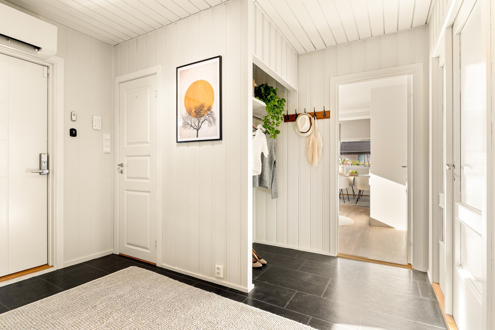 Lys og romslig entrè med god plass til oppbevaring. I tillegg til varmepumpe i stuen er det også montert varmepumpe over inngangsdøren. Galleribilde