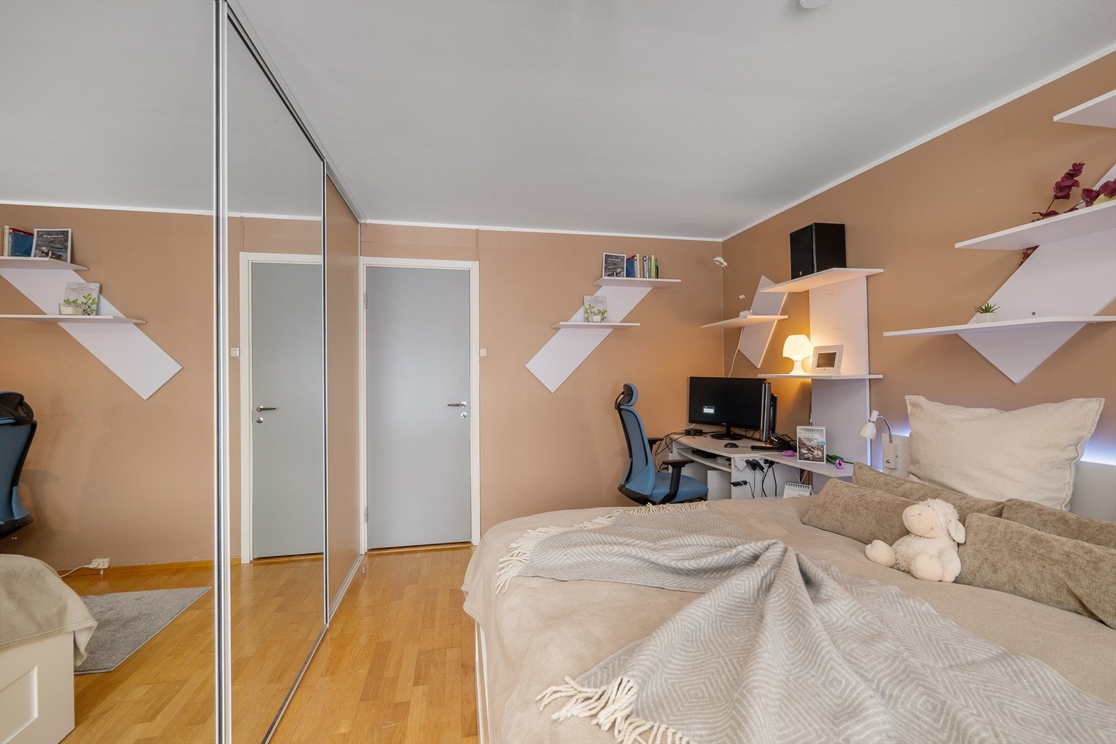 En stor garderobe med skyvedører og speilfronter gir rikelig med oppbevaringsplass. Galleribilde