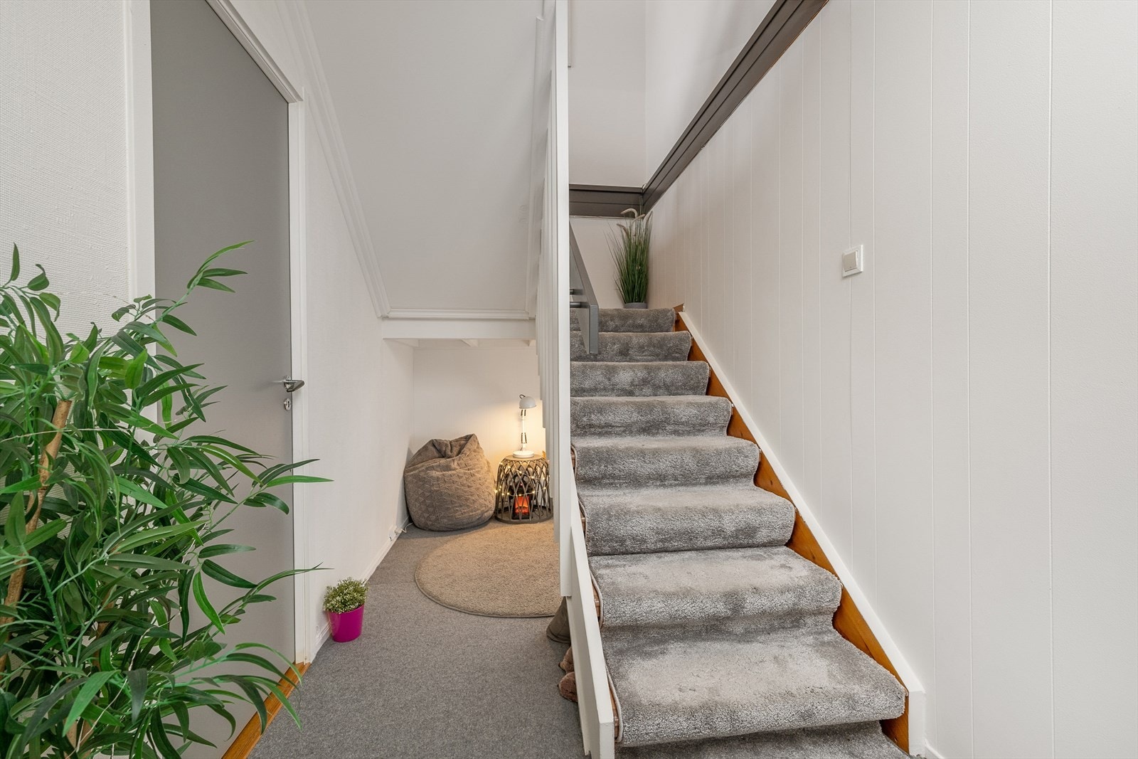 En innvendig trapp i heltre med teppebelagte trinn leder ned til underetasjen. Galleribilde