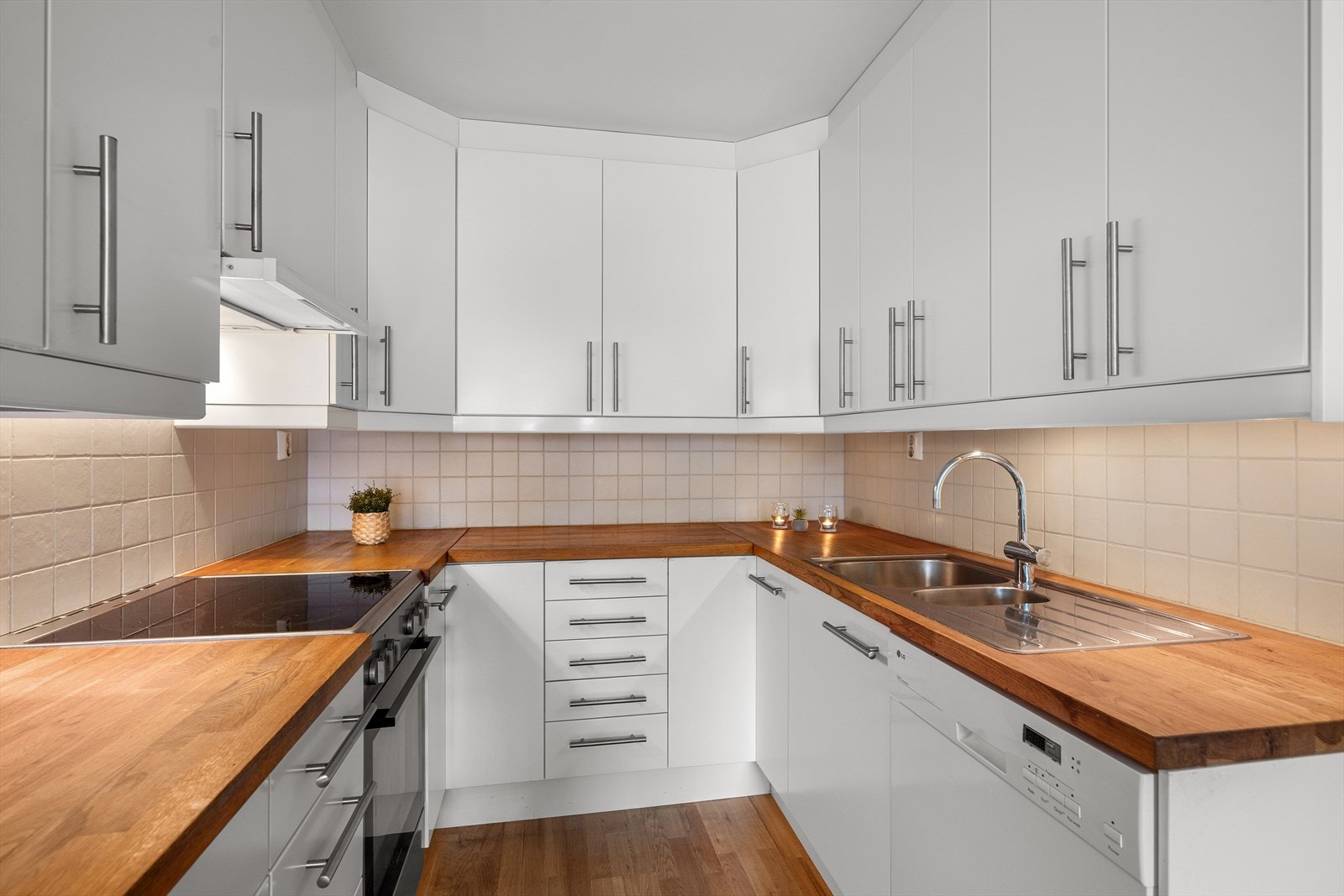 Kjøkkenet er innredet med glatte fronter og heltre benkeplate med nedfelt oppvaskkum i rustfritt stål. Godt med skap og benkeskap. Galleribilde