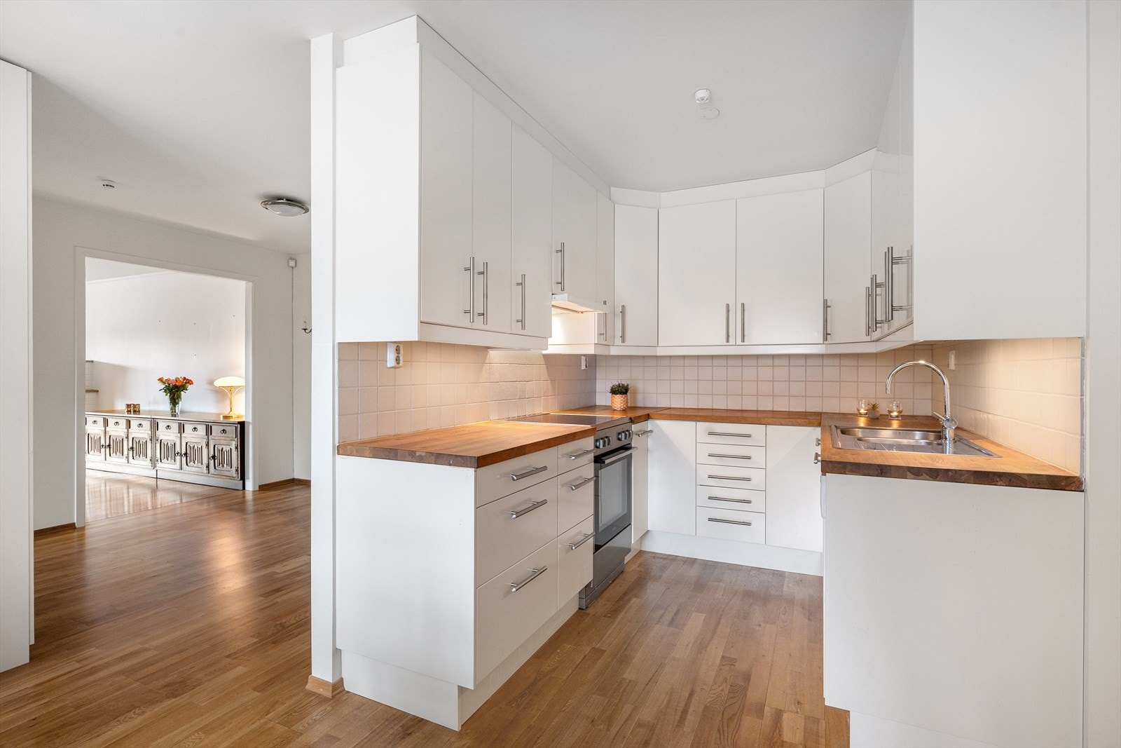 Det er fliser på vegg over benkeskap samt belysning under overskap. Kjøkkenet har ventilator og opplegg for oppvaskmaskin. Galleribilde