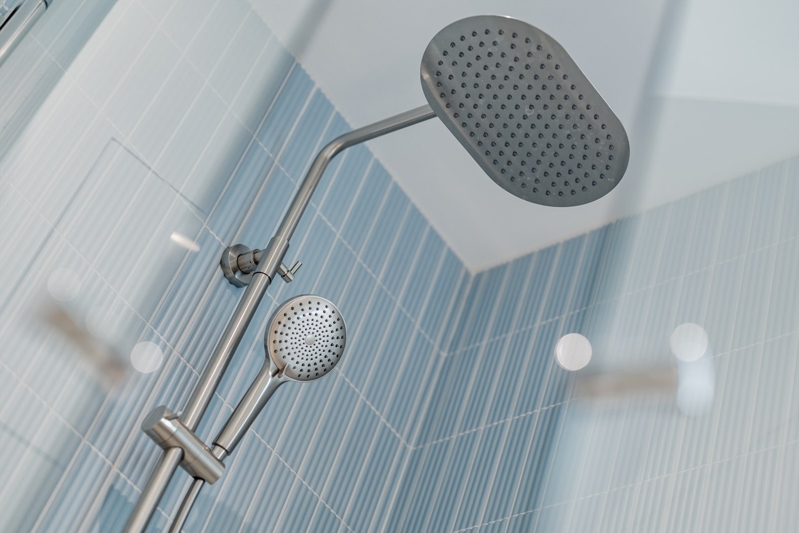 Stilige detaljer i blått, regnfallsdusj og håndholdt dusjhode. Galleribilde