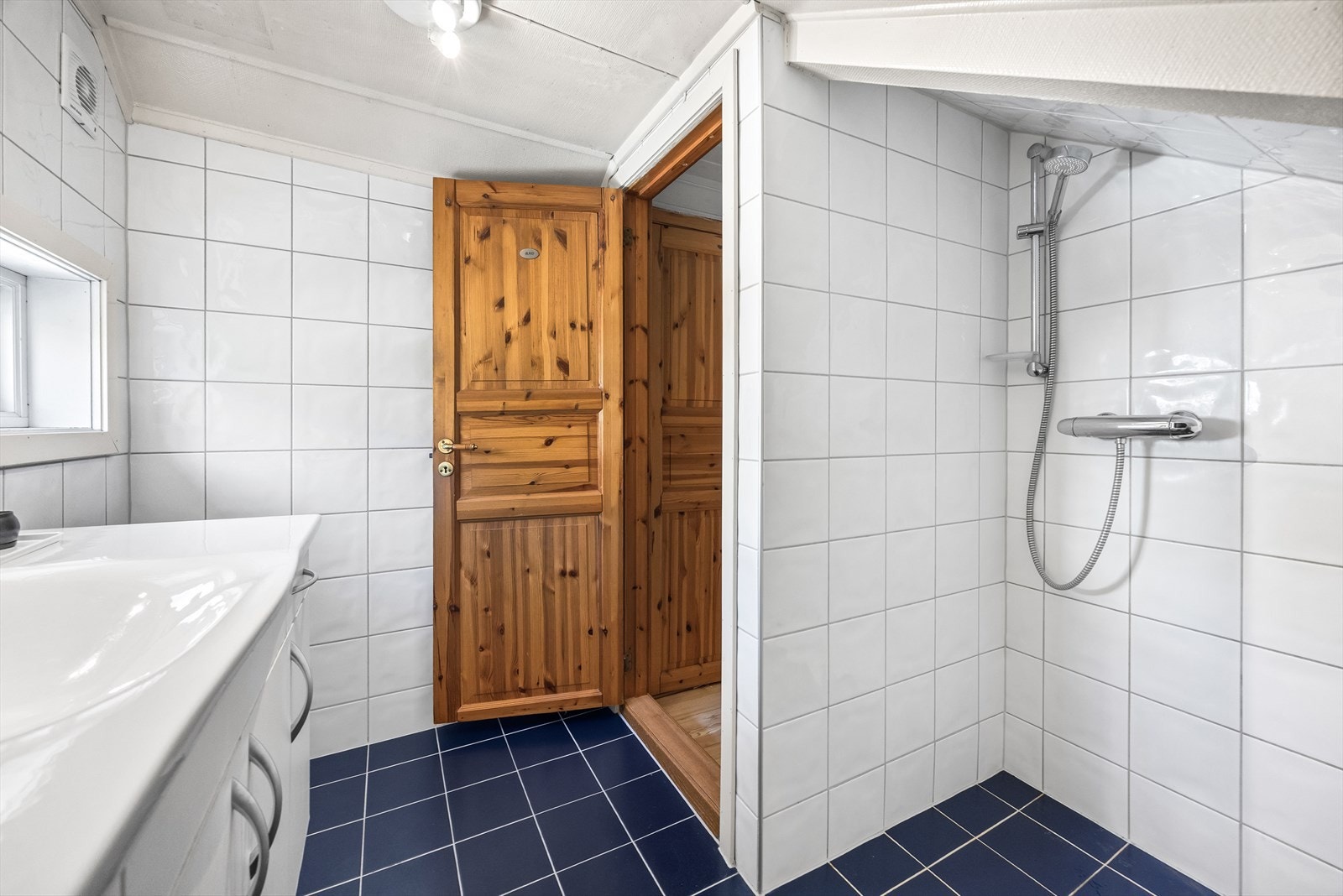 Baderommet fra 2006 har en enkel innredning med servant og dusj, men er opprinnelig godkjent som bod Galleribilde