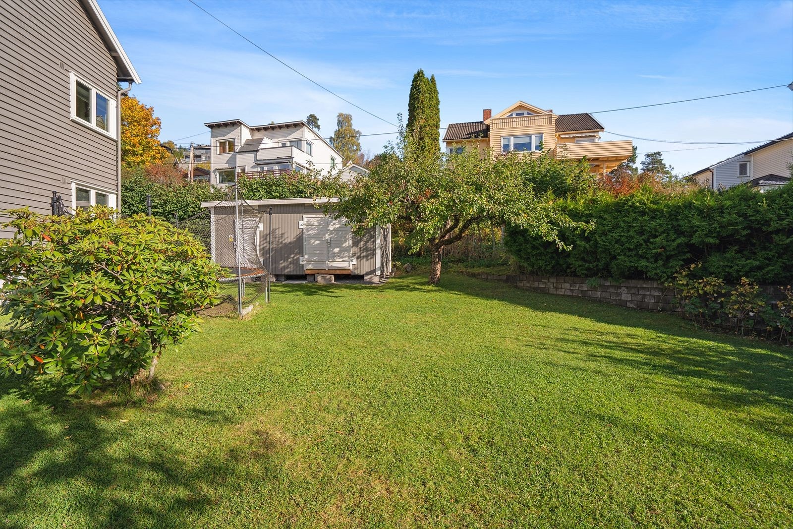 Det er hekk, gjerder og støttemur som omringer tomten Galleribilde