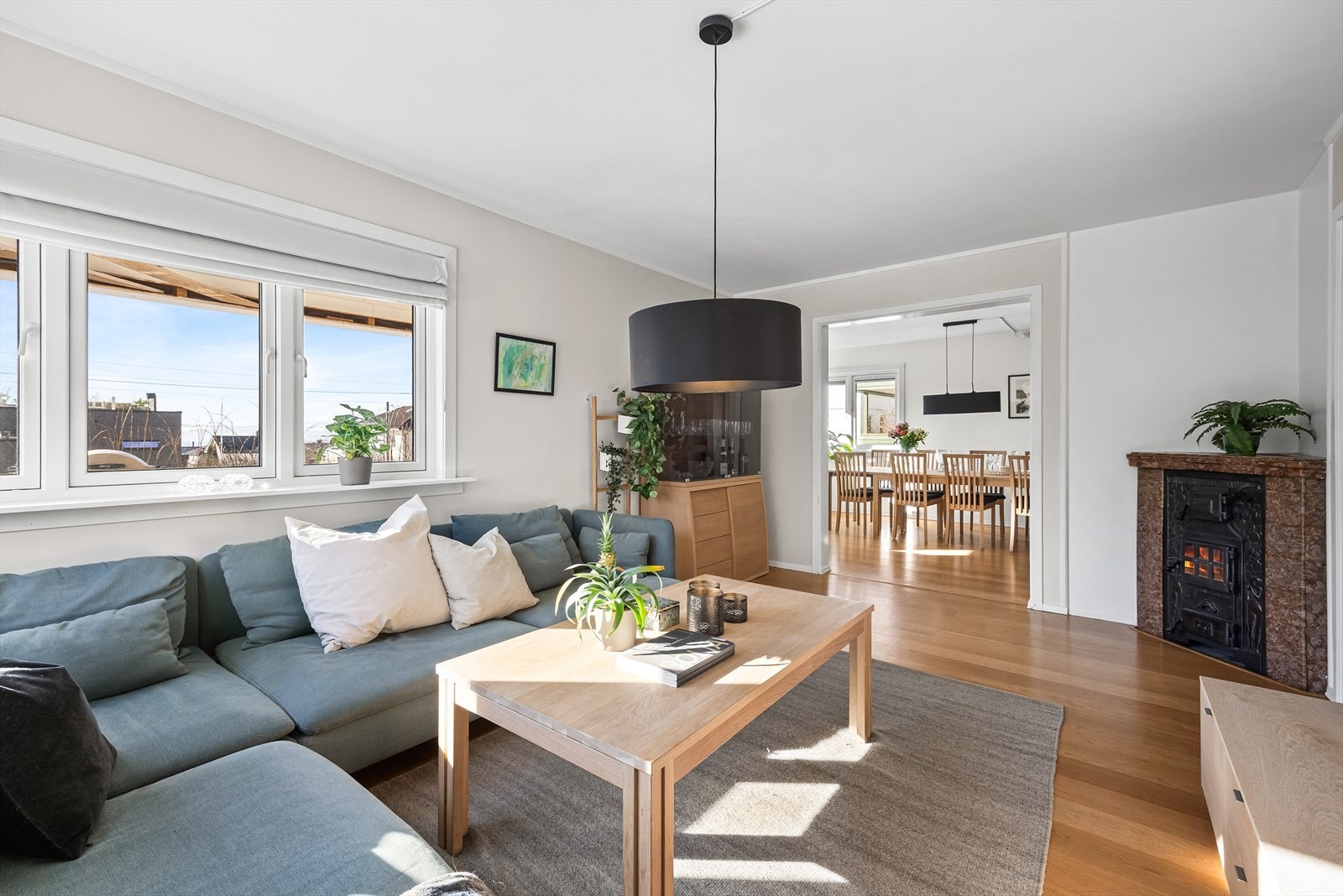 Rommet er sosialt med peis og ligger i delvis åpen løsning til spisestuen Galleribilde