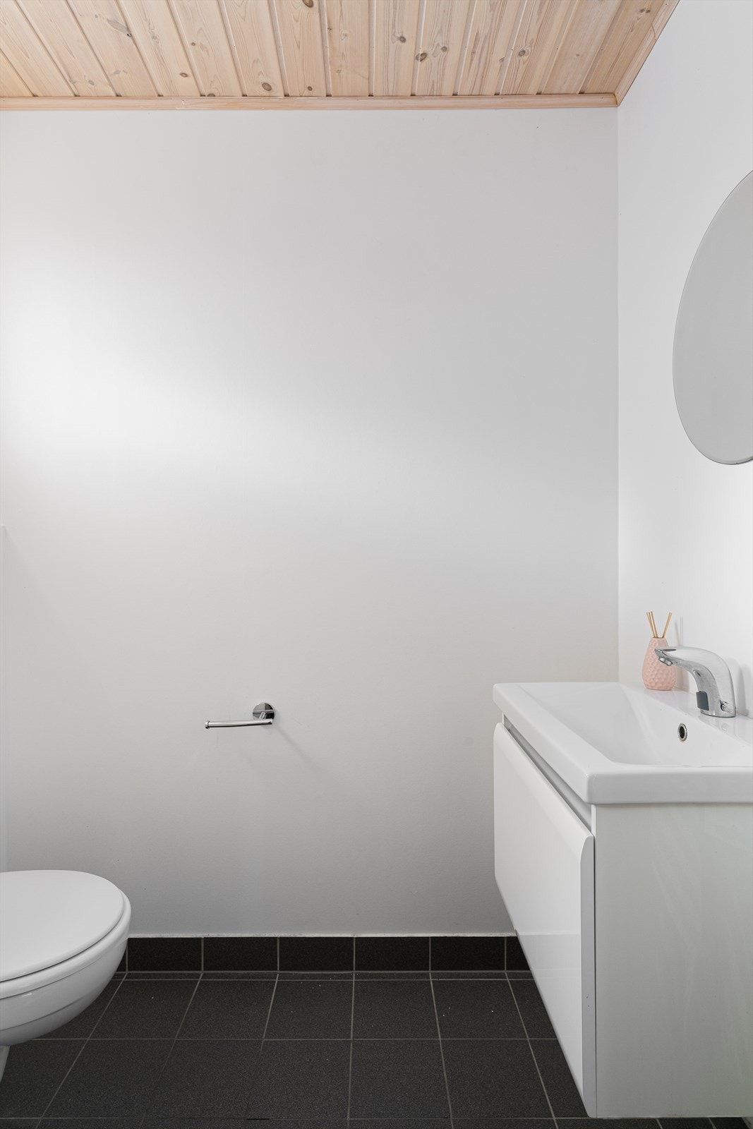 Tilbaketrukket gjestetoalett ved entré med fliser på gulv. Galleribilde